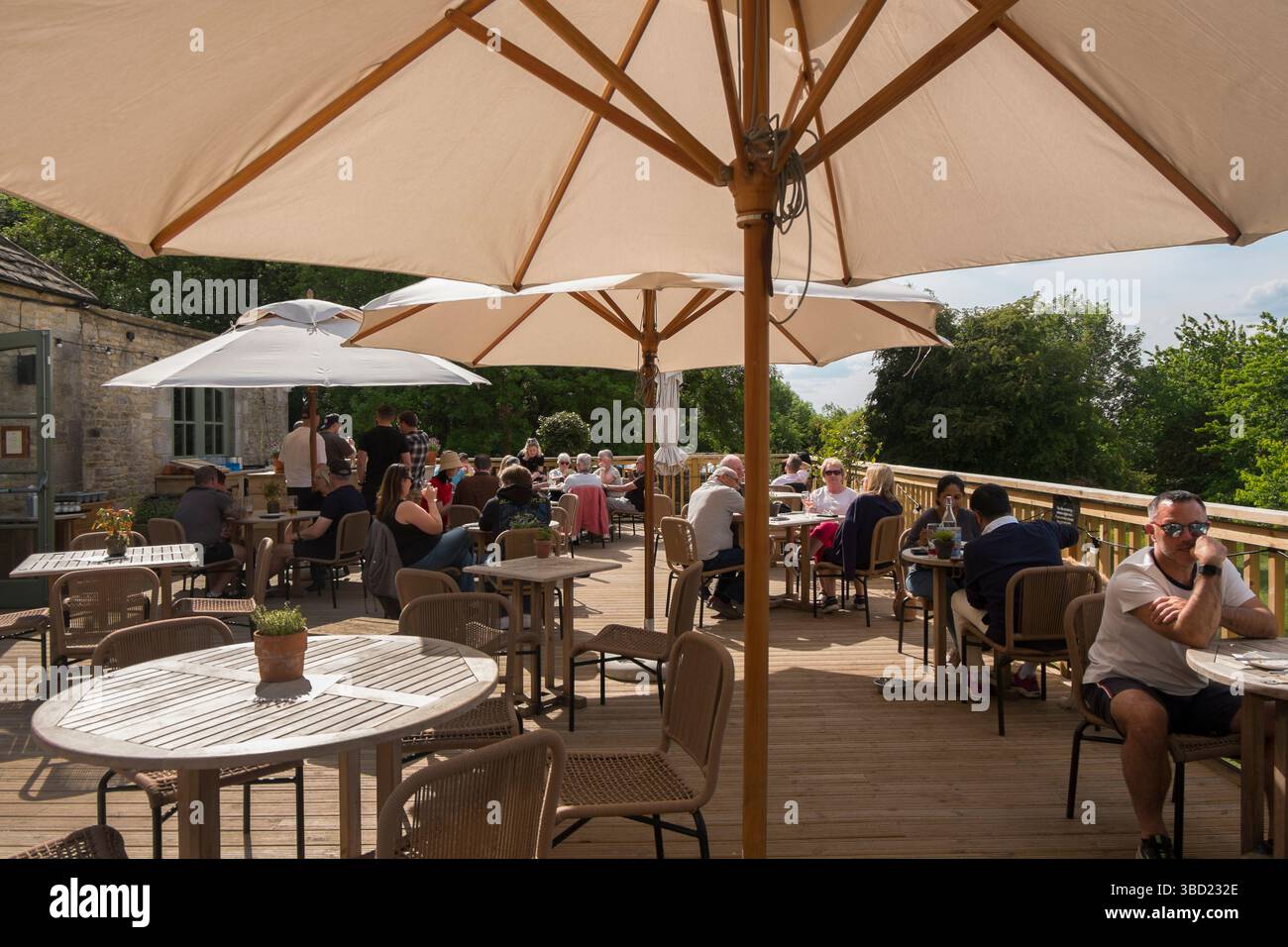 Die Terrasse mit Blick auf das Windrush Valley in Jeremy Clarkson's Pub, The Farmer's Dog, in den Cotswolds, Großbritannien. Stockfoto