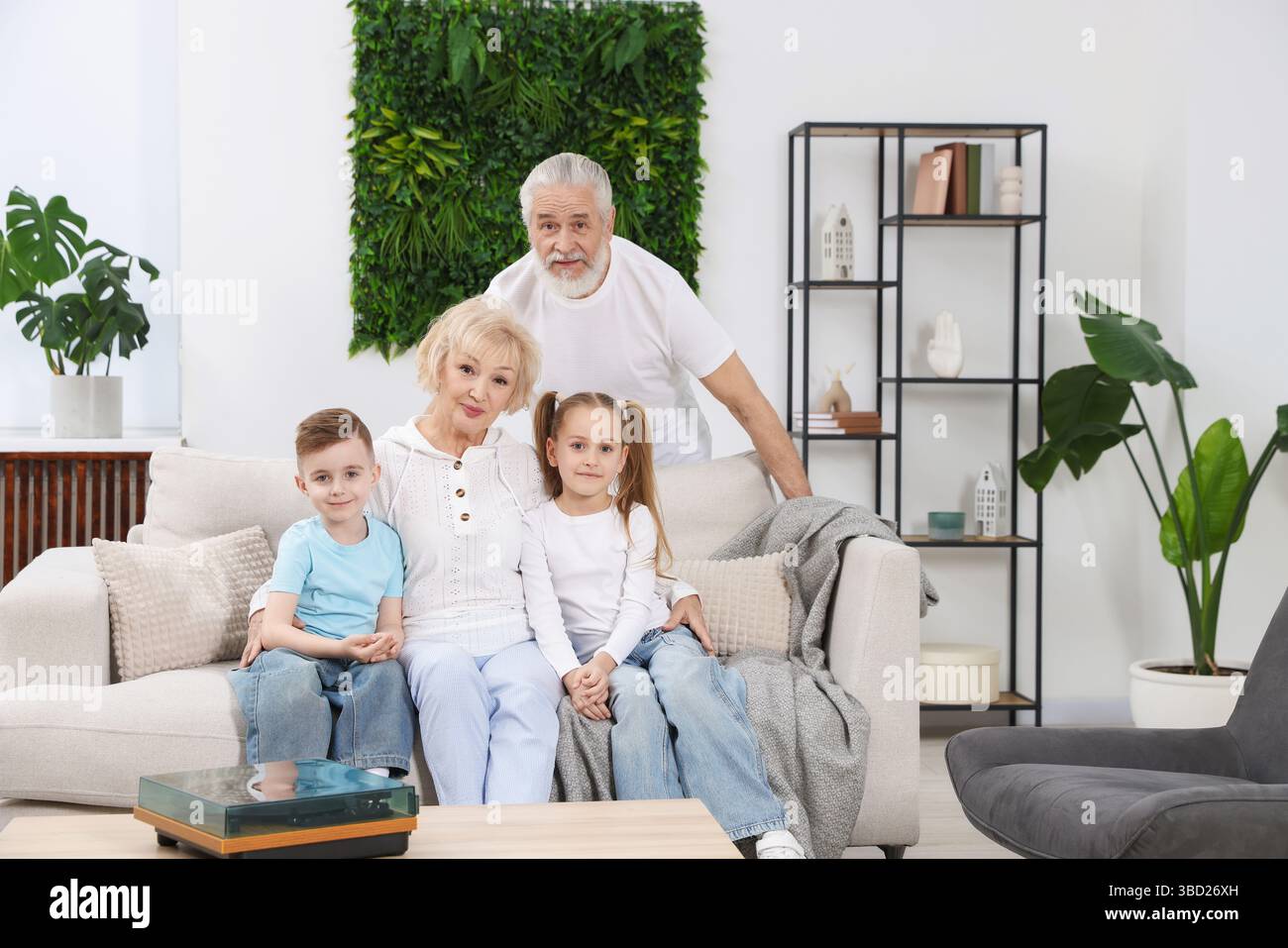 Porträt der Großeltern mit ihren Enkeln zu Hause Stockfoto