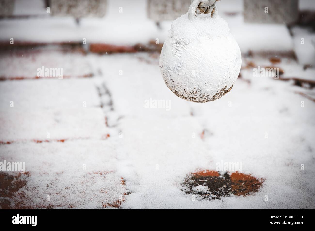 Schnee sammelt sich auf dem Ball eines Tores näher an einer Außentür in Colonial Williamsburg, Virginia. Stockfoto