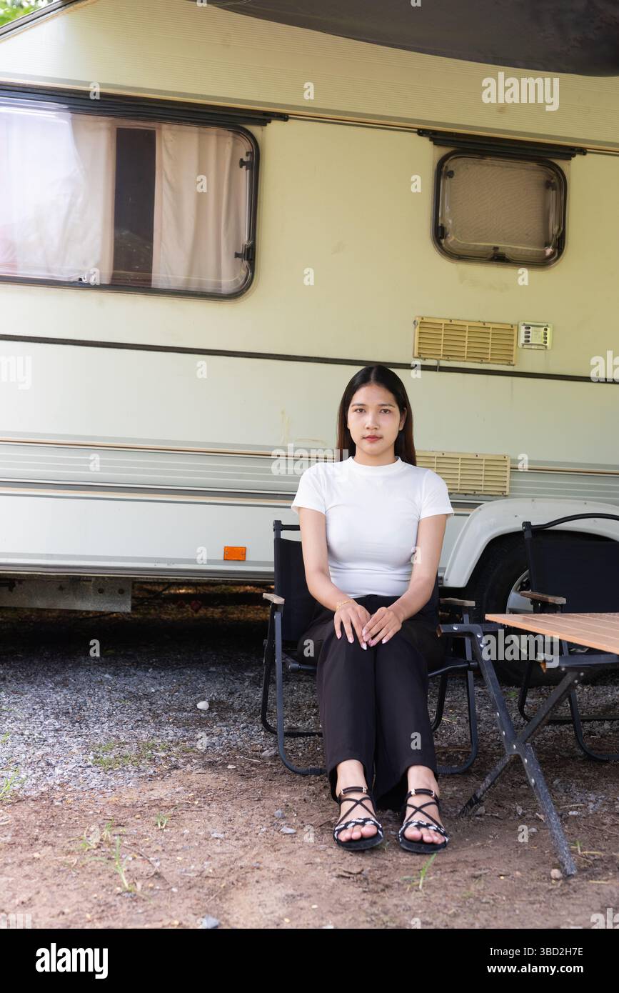 Junge Frau, die im Sommer Camping und Vanlife mit Wohnwagen genießt Stockfoto