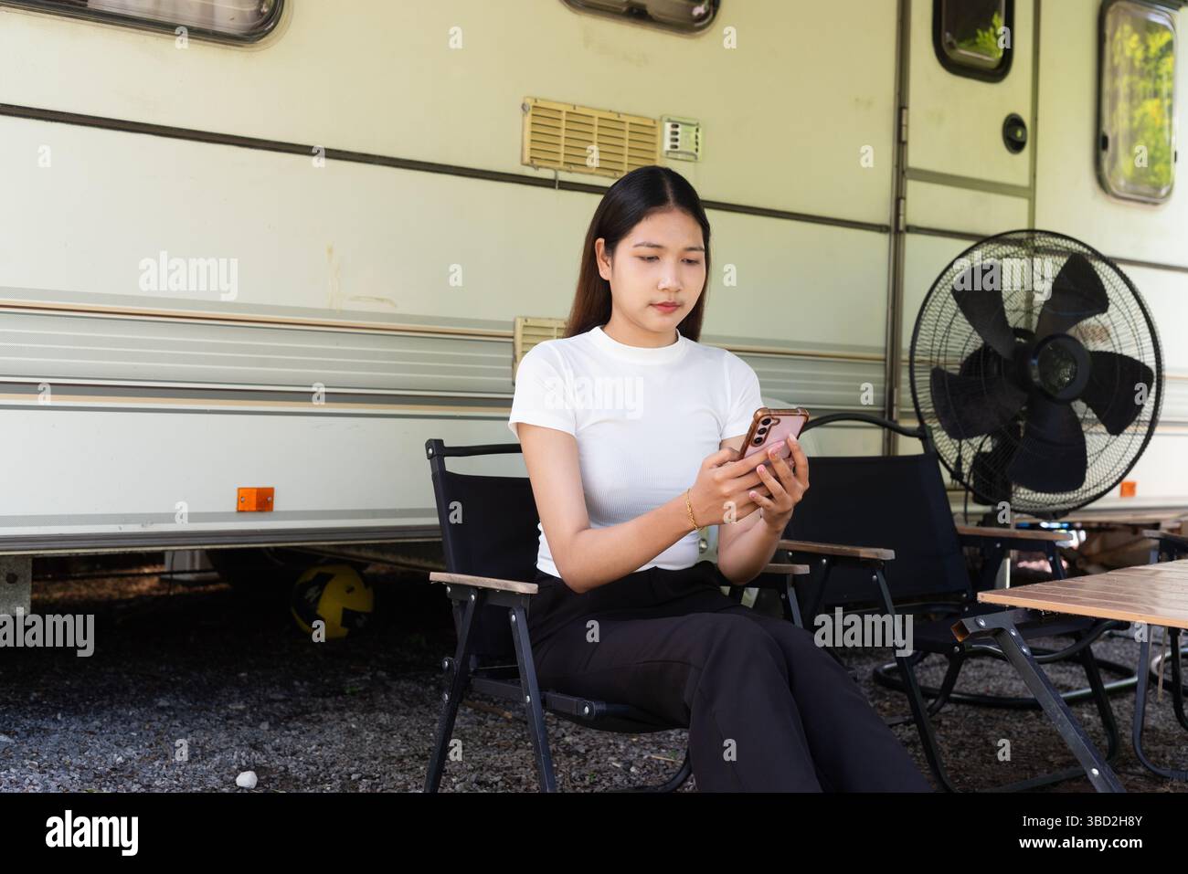 Junge Frau, die im Sommer Camping und Vanlife mit Wohnwagen genießt Stockfoto