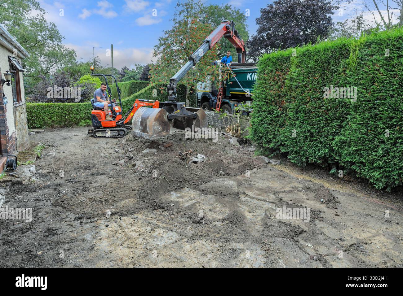 Landschaftsgestaltung eines Vorgartens mit einem kleinen Kubota Minibagger und einem LKW-Greifer, Stoke-on-Trent, Staffordshire, England, Großbritannien Stockfoto