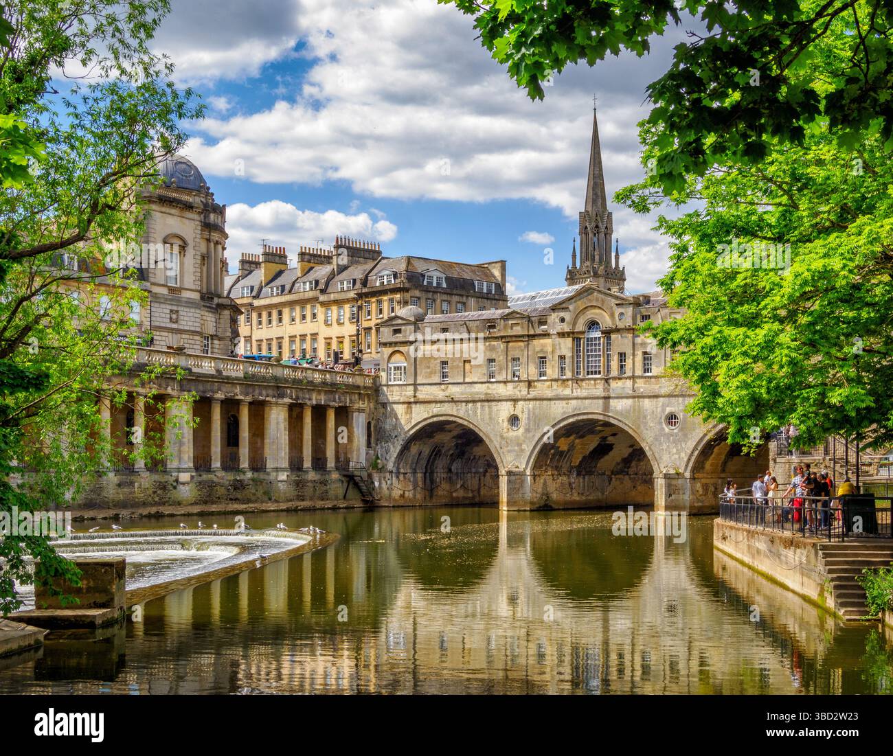 Pulteney Bridge und Wehr am Fluss Avon in der Stadt Bath Somerset UK - die berühmte Brücke führt über eine Straße voller Geschäfte Stockfoto