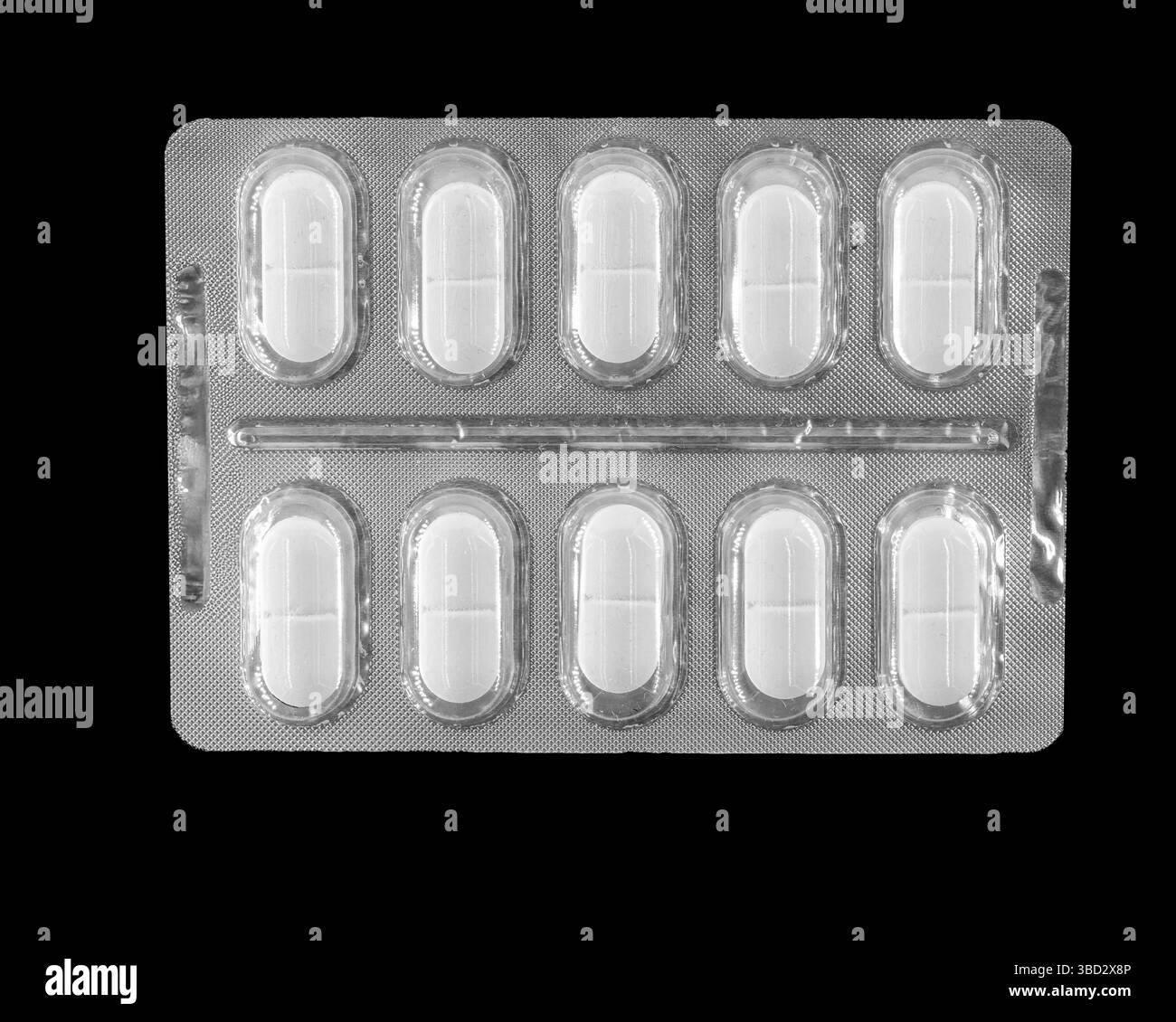 Eine Blisterpackung mit weißen Kapseln ist auf schwarzem Hintergrund abgebildet. Die Kapseln sind ordentlich in zwei Reihen angeordnet und zeigen ihre Uniformen Stockfoto