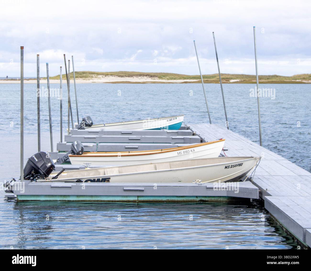 Kleine Boote finden Ruhe an einem rustikalen Dock, das tief in den ruhigen Sumpfkanälen liegt. Eine perfekte Szene des friedlichen Küstenlebens. Stockfoto