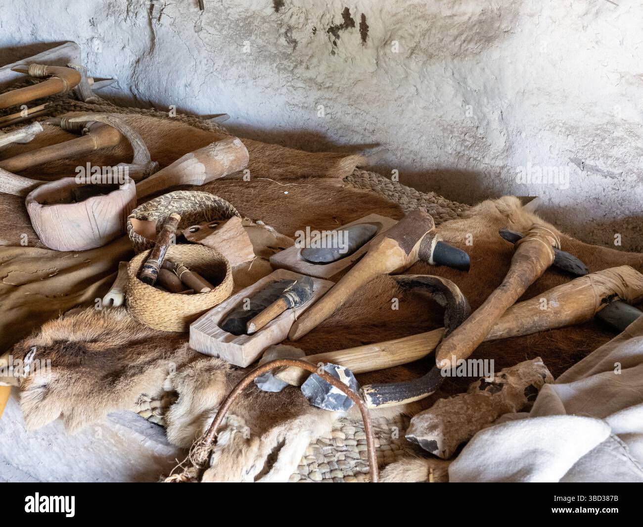 Steinäxte und andere Werkzeuge in einer rekonstruierten steinzeitlichen Hütte in Stonehenge in Wiltshire, Großbritannien. Stockfoto