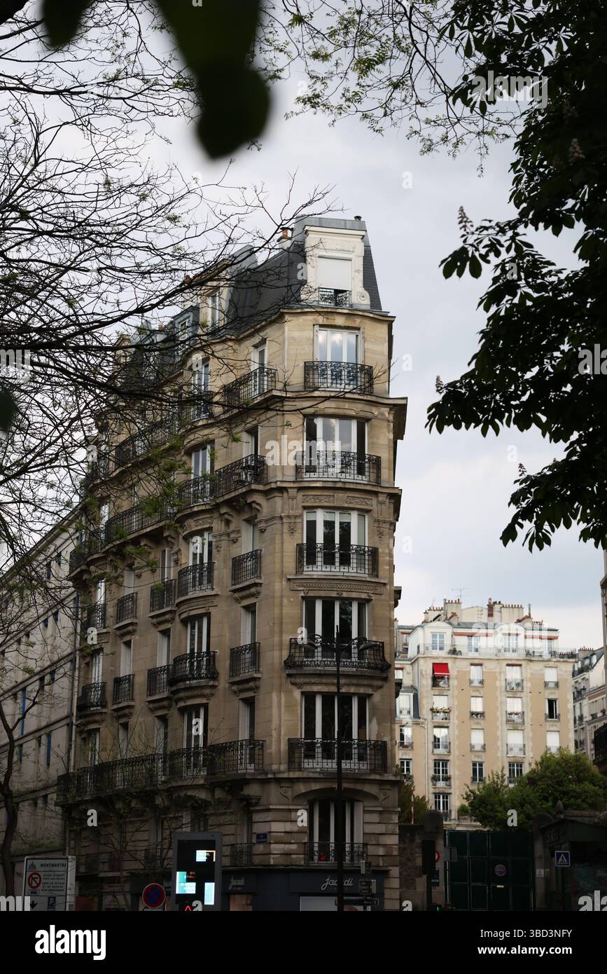 Ein wunderschön gestaltetes mehrstöckiges europäisches Wohngebäude verfügt über verzierte Balkone, schwarze schmiedeeiserne Geländer und große Fenster, die von e eingerahmt werden Stockfoto