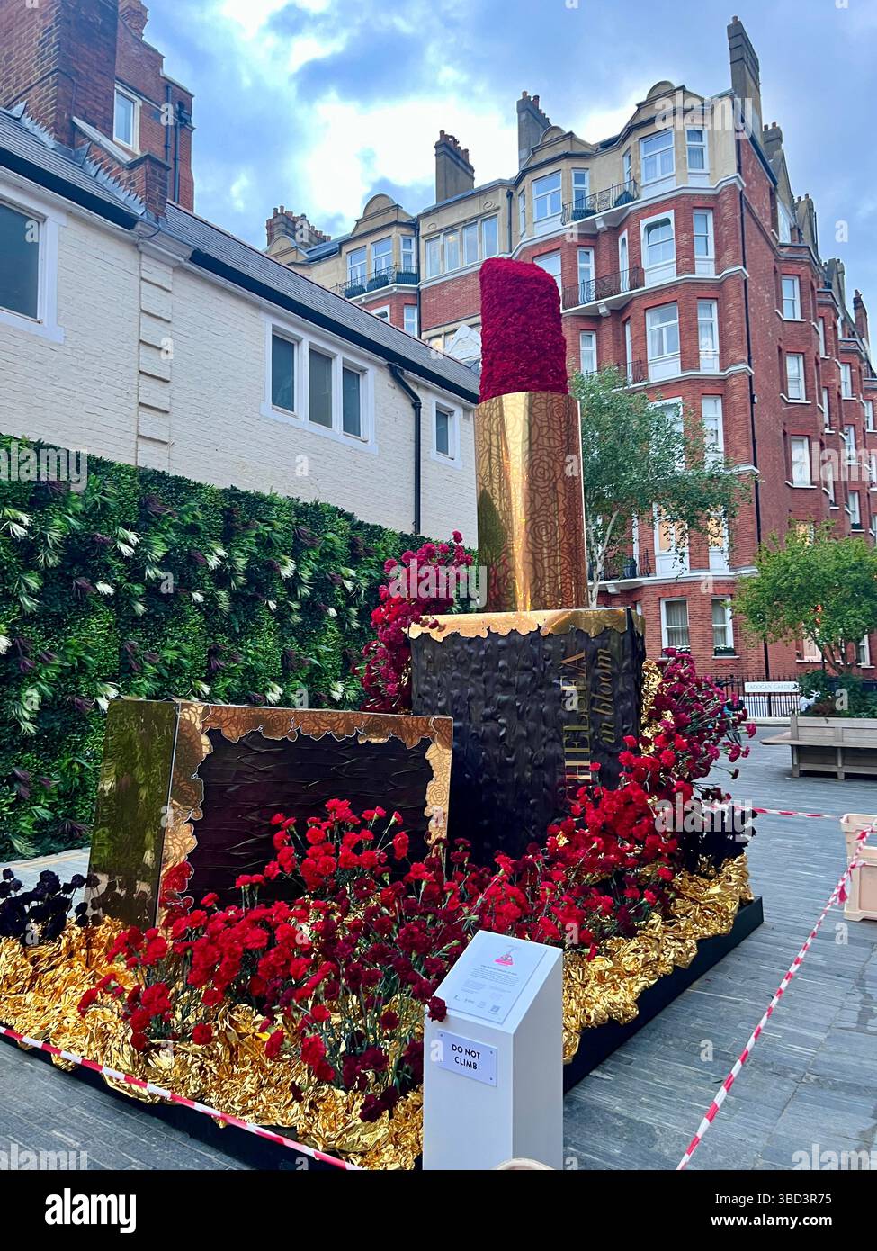Chelsea in Bloom 2025, aufwendige Blumendekoration in Form eines Lippenstiftetui und rotem Lippenstift. Aufgenommen in Chelsea, London. Keine Personen Stockfoto