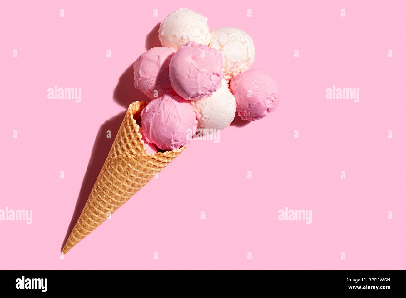 Eisbecher mit Erdbeeren- und Vanillekugeln auf rosa Pastellhintergrund, kreative flache Lay, Kopierraum. Viele leckere Bio-Eissorten werden eingelegt Stockfoto