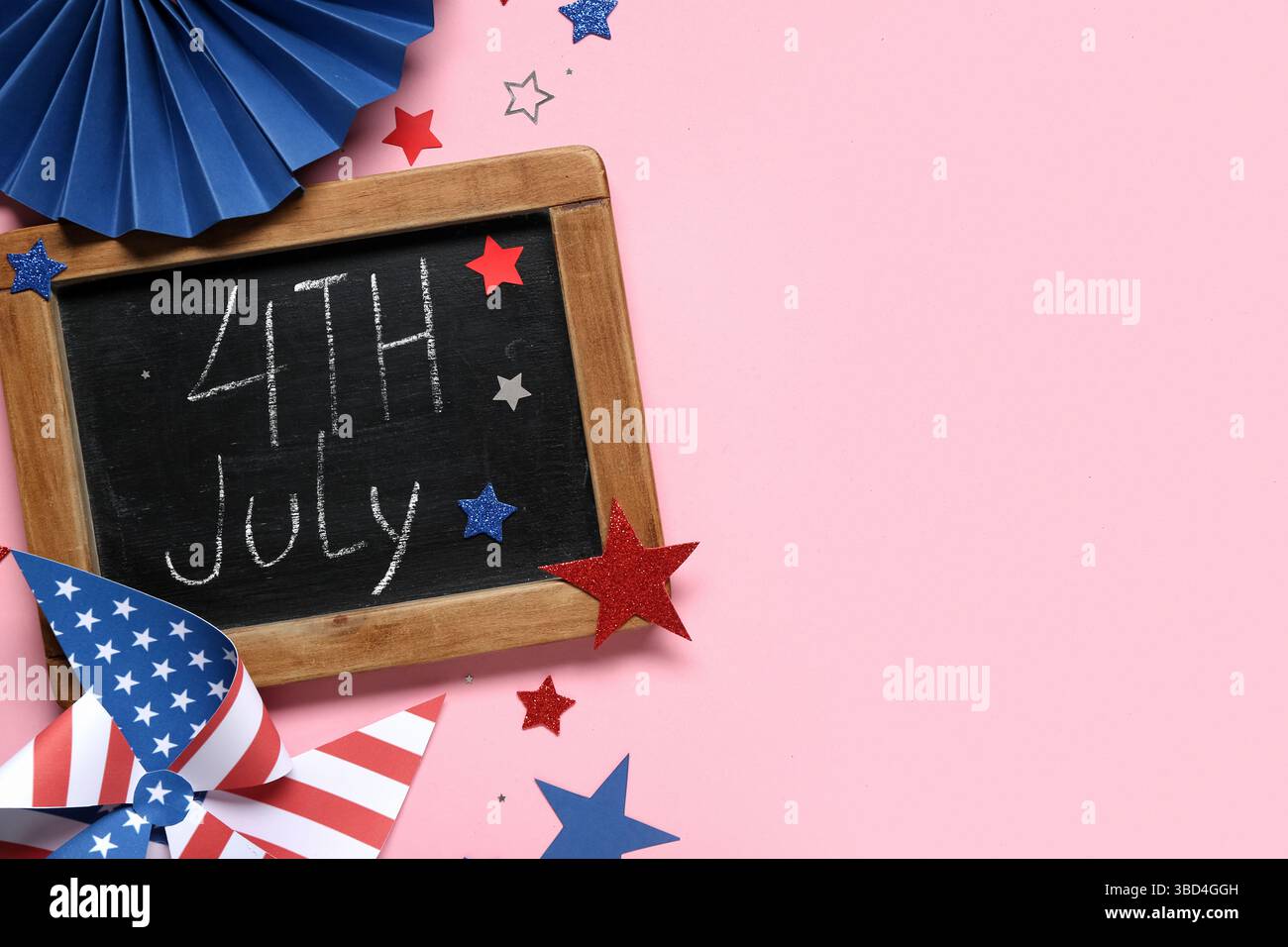 Kreidetafel mit Text 4. JULI, Windrad aus USA-Flaggen und Sternen auf rosa Hintergrund. Unabhängigkeitstag Stockfoto