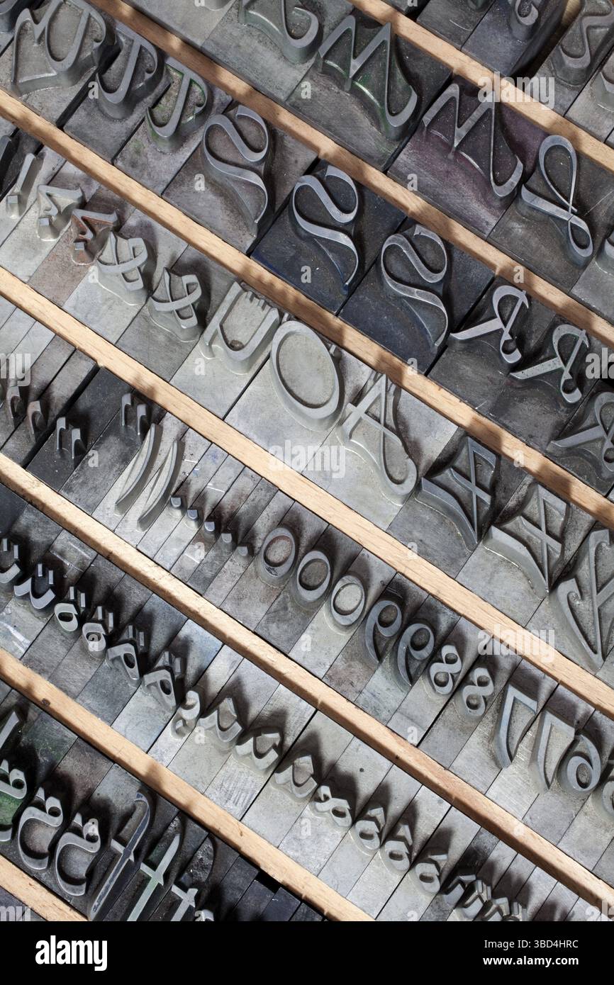 Heißes Metall, alte Buchstaben aus Blei für den Buchdruck, kursive Schrift im Briefkasten Stockfoto
