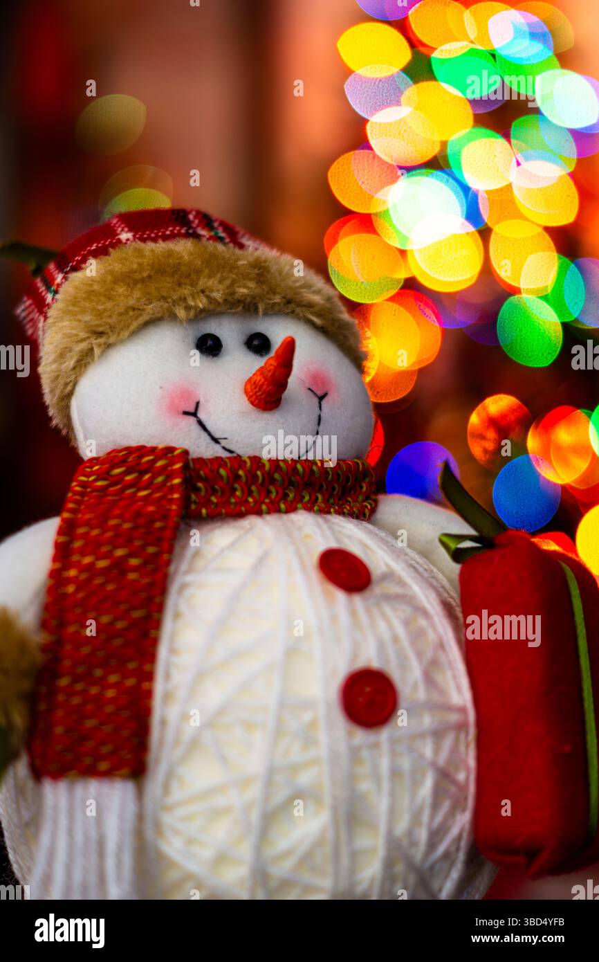 Frosty the Snowman mit Weihnachtsbaumlichtern im Hintergrund Stockfoto