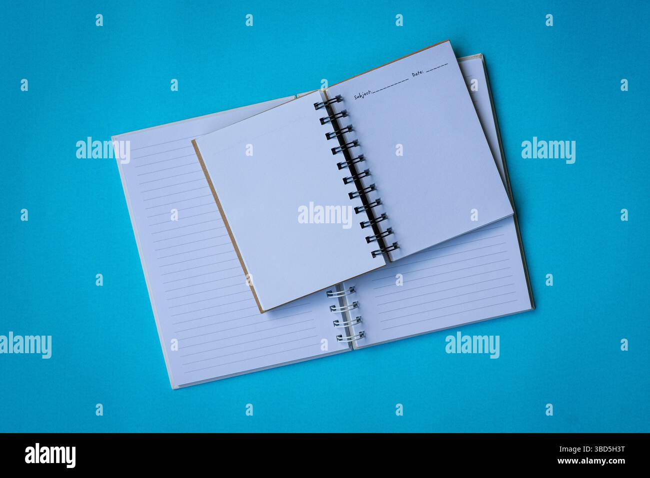 Zwei offene Notizbücher auf blauer Oberfläche. Flache Lagen oder Draufsicht. Stockfoto