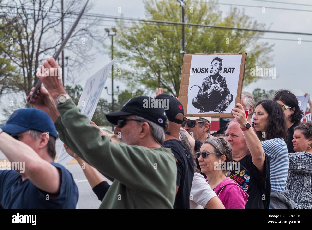 Duluth, GA / USA - 29. März 2025: Demonstranten zeigen Anti-Elon-Musk-Zeichen bei einer „Tesla Takedown“-Protestveranstaltung am 29. März 2025 in Duluth, GA. Stockfoto