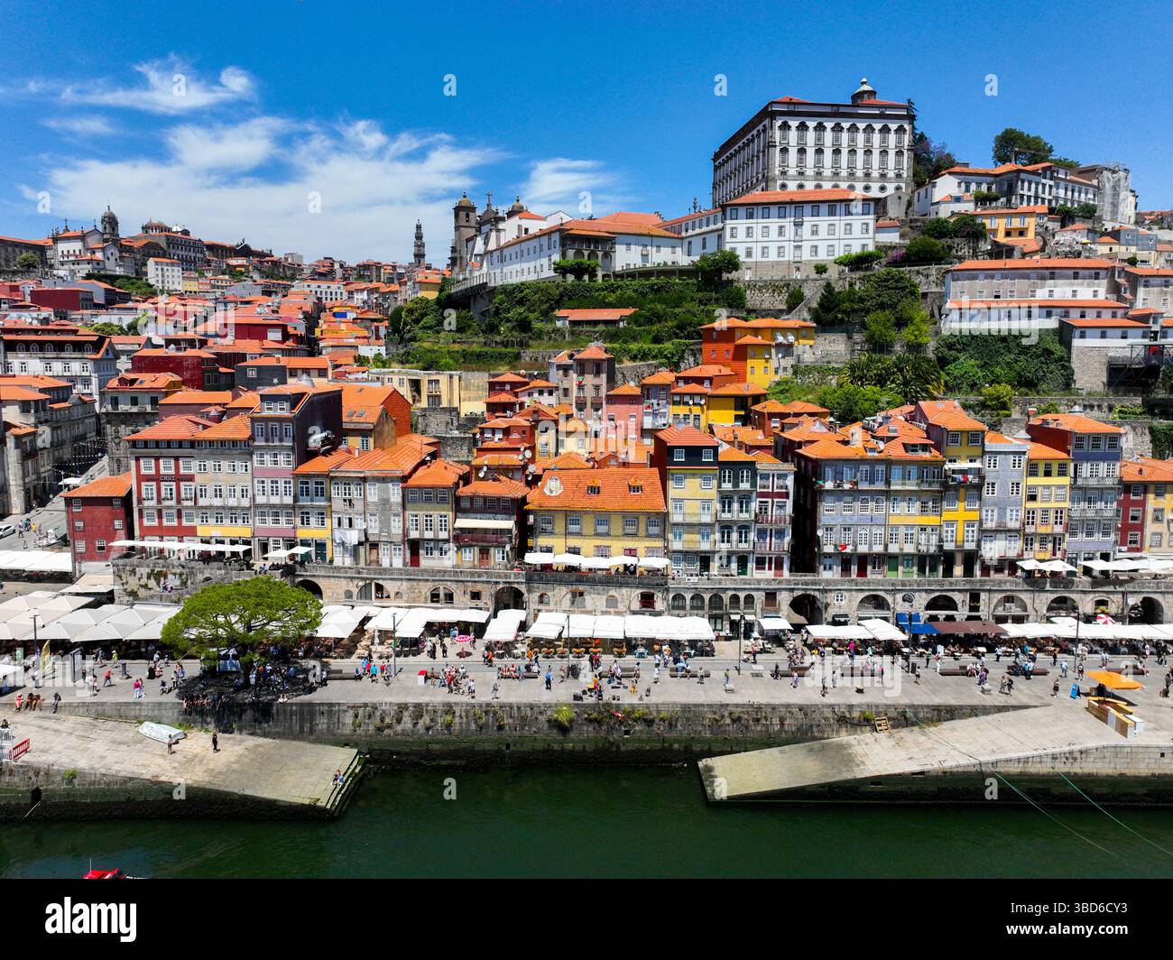 Porto, Portugal - 12. Mai 2024: Ribeiras Flussufer mit bunten Häusern und Touristen am Kai Stockfoto