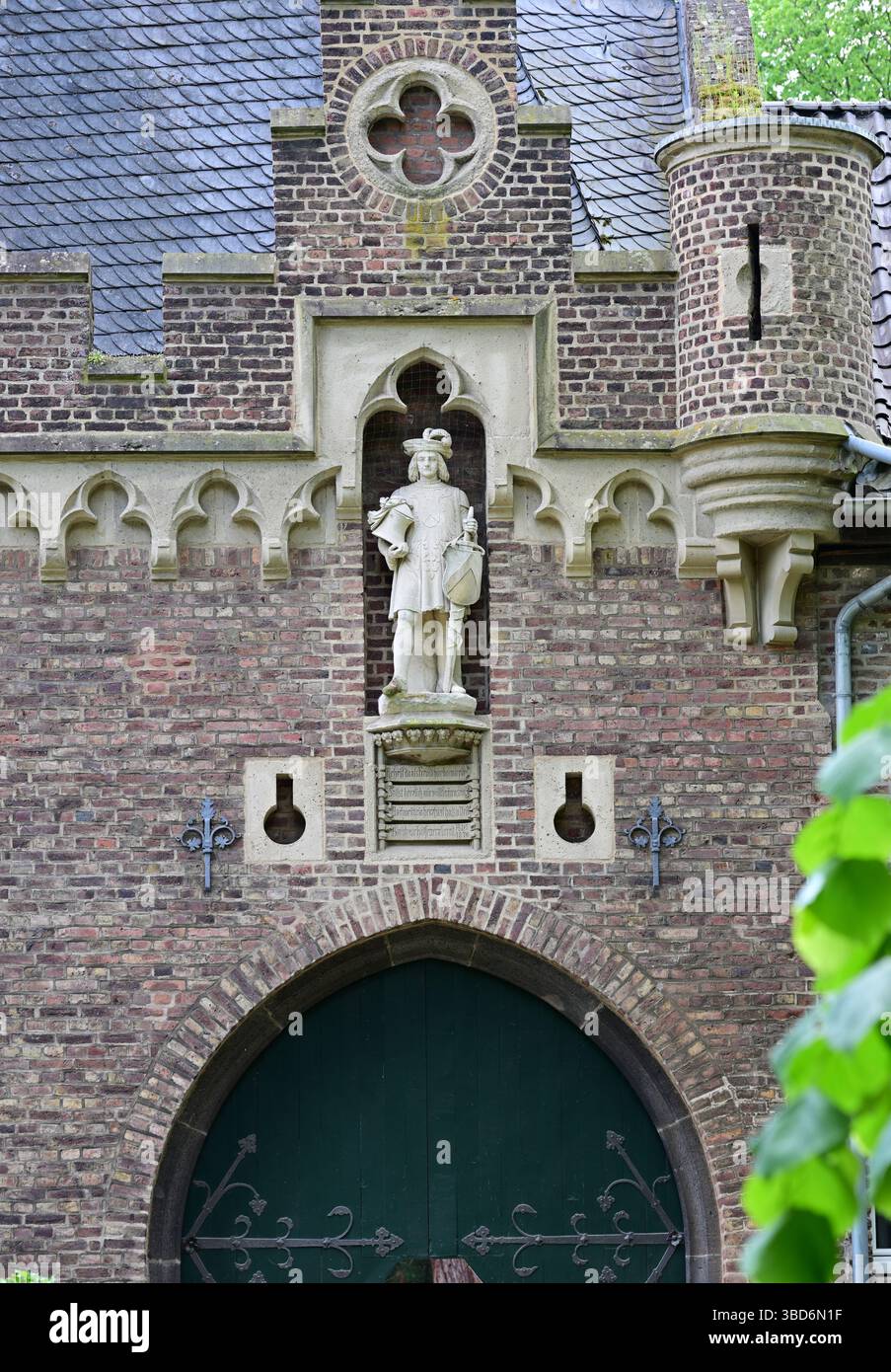 Historisches Schloss Paffendorf in Bergheim, Deutschland, mit neogotischer Architektur, einem runden Turm mit Zinnen und einer malerischen Parklandschaft Stockfoto
