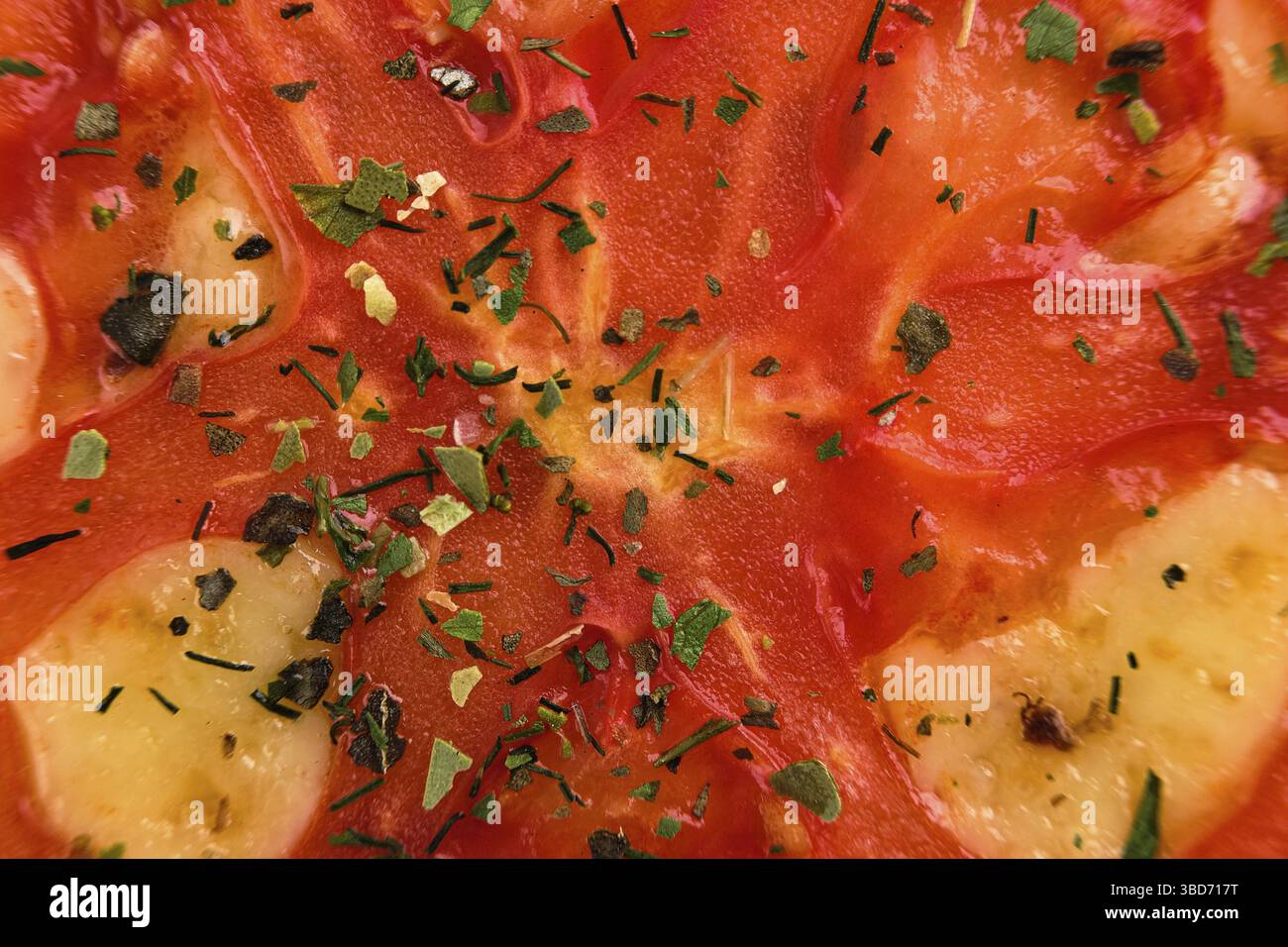 Makrofoto von Tomate mit trockenen Kräutern auf Pizza (Foto mit geringer Schärfentiefe) Stockfoto