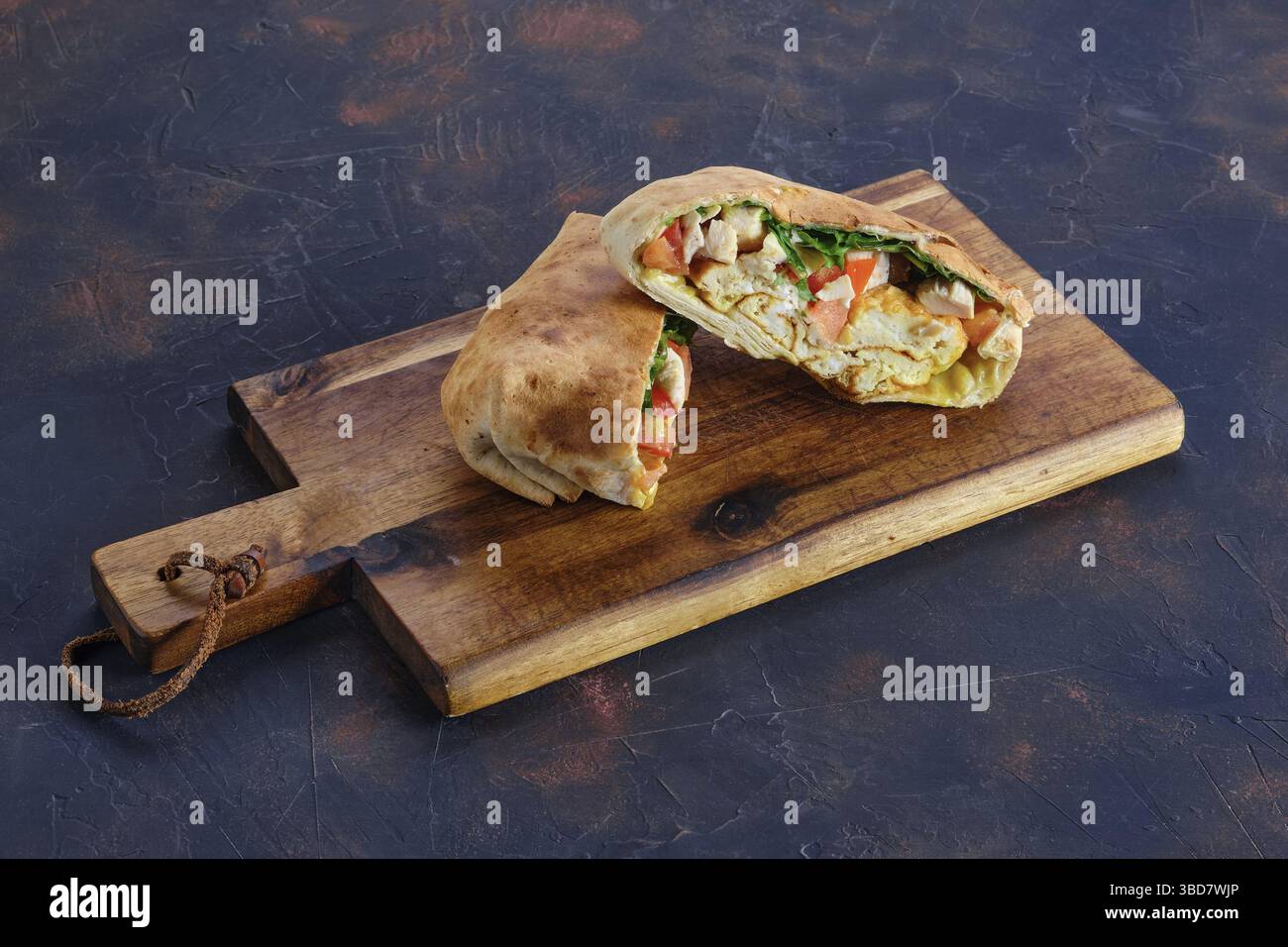 Fladenbrot gefüllt mit Hähnchen, Tomaten und Omelette Stockfoto