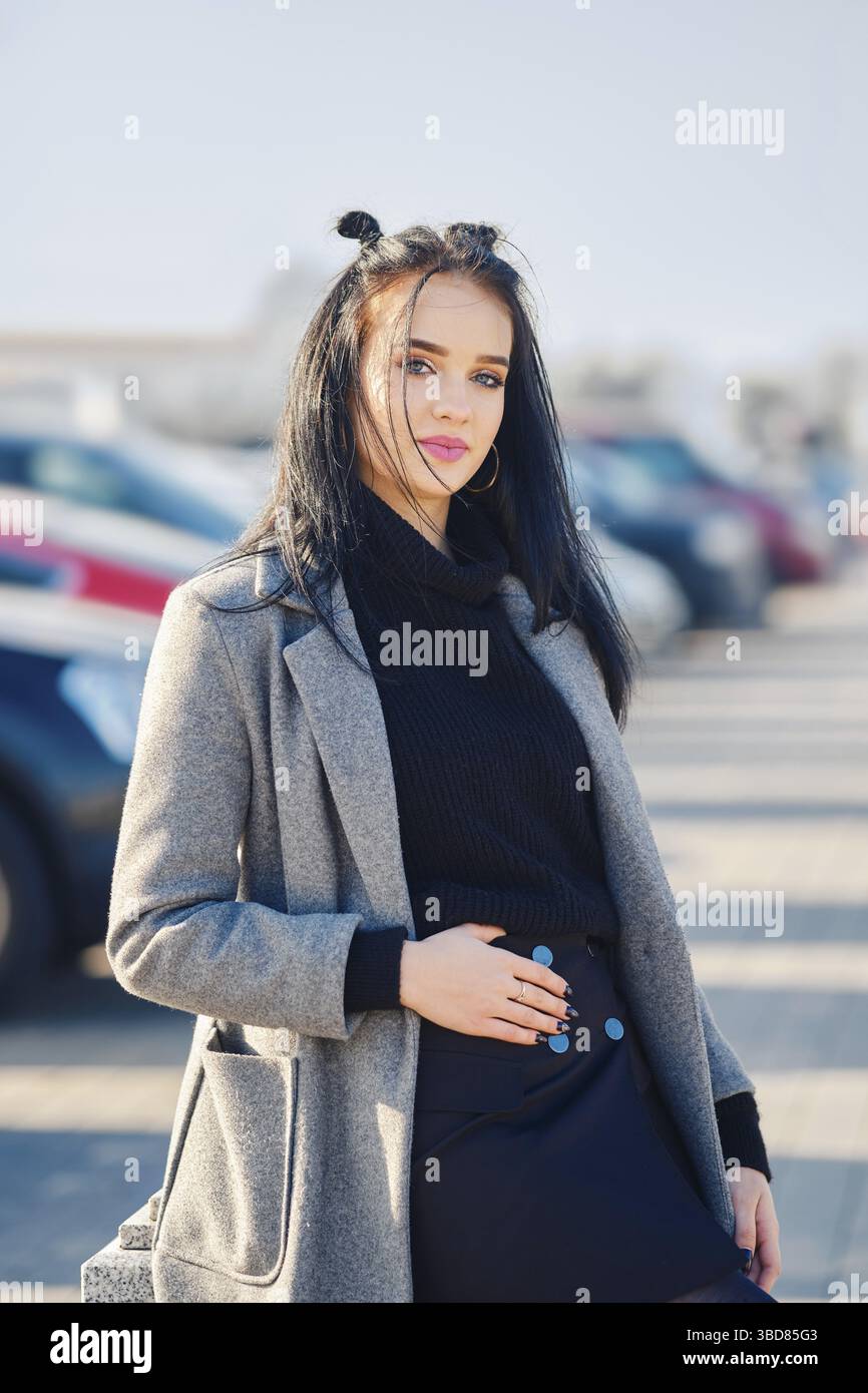 Junge Frau posiert in der Nähe des Parkplatzes in der Nähe des Einkaufszentrums Stockfoto