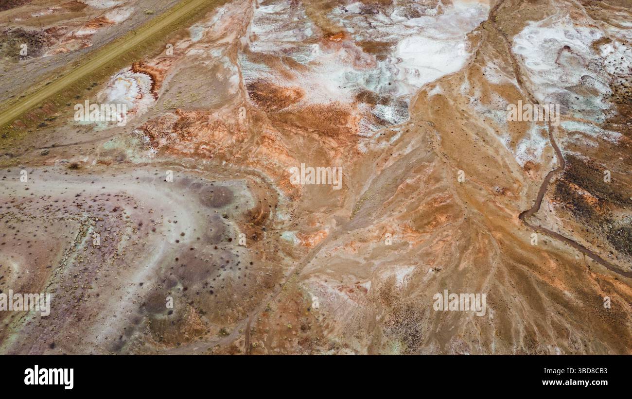 Luftaufnahme abstrakter augenähnlicher Mineralmuster im Wüstengelände Stockfoto