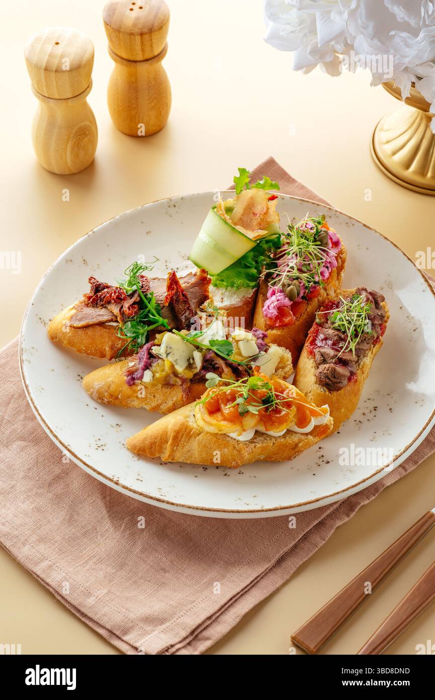Gemischte Bruschetta mit Belägen auf einem Teller Stockfoto