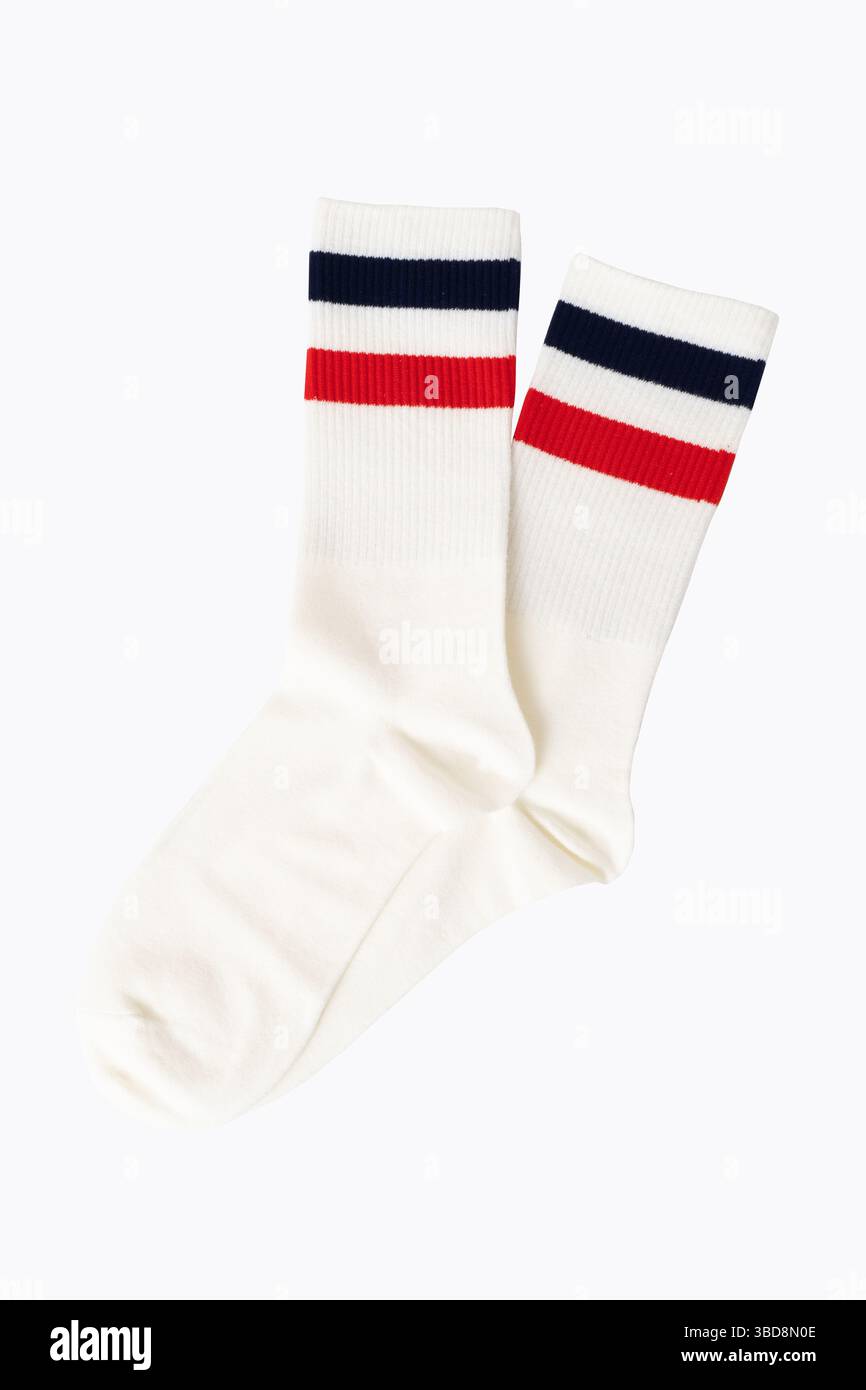 Weiße Sportsocken mit roten und marineblauen Streifen auf einfarbigem Hintergrund Stockfoto