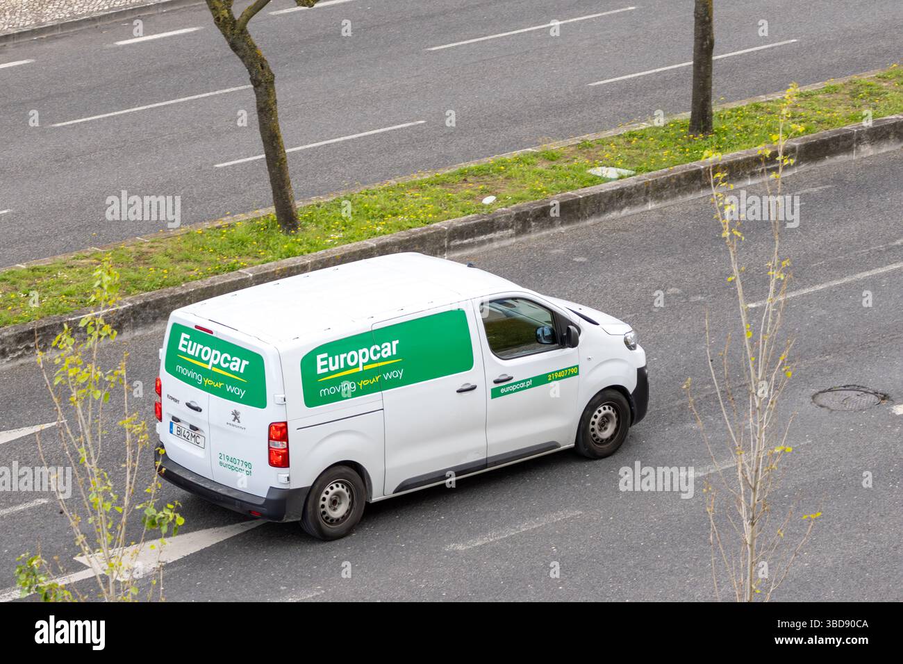 Weißer europcar-Van, der auf Asphaltstraßen fährt und Transport- und Logistikdienstleistungen anbietet Stockfoto