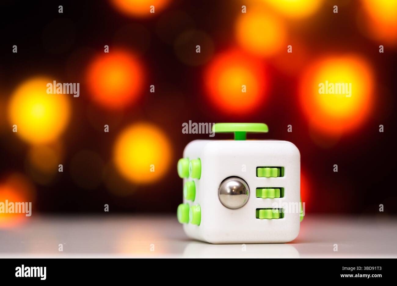 Fidget Cube Antis Stressspielzeug. Detail des Spielzeugs, das zum Entspannen verwendet wird. Gadget auf farbenfrohem Bokeh-Hintergrund. Stockfoto