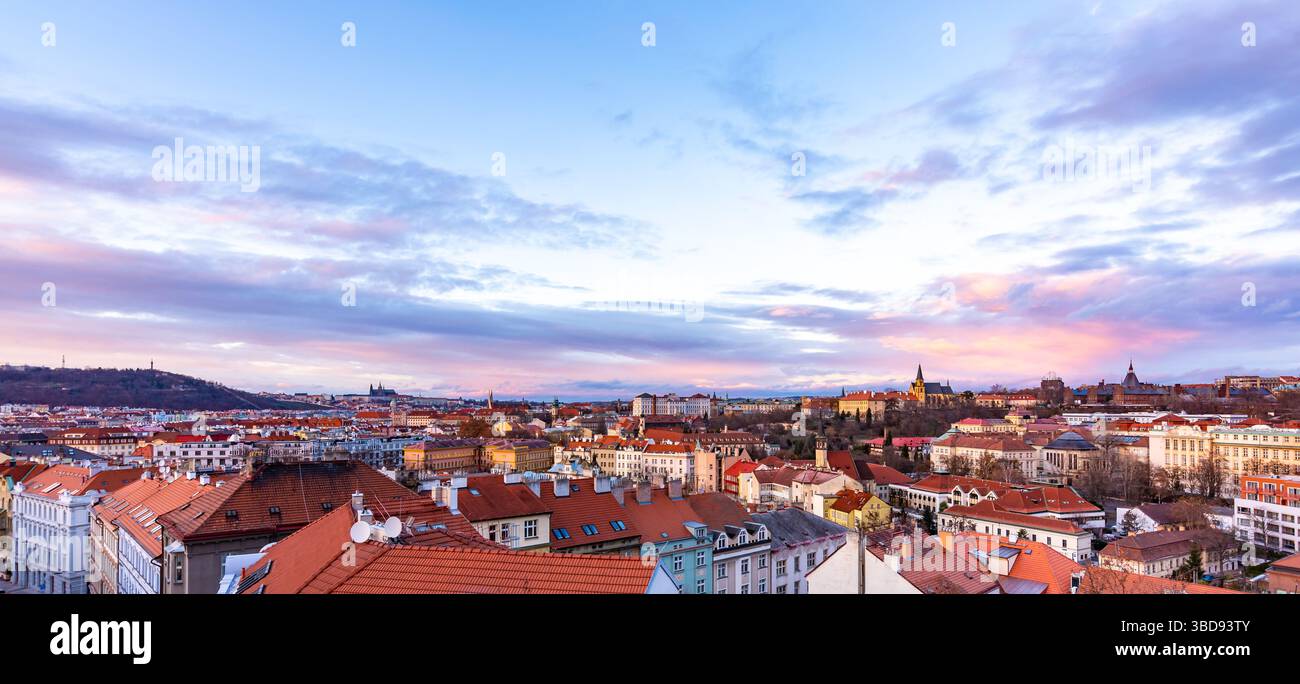 Prager Panoramablick vom Schloss Vysehrad. Stadtbild während des Sonnenuntergangs, magische und wunderschöne Farben. Bunte Wolken über der tschechischen Hauptstadt. Stockfoto