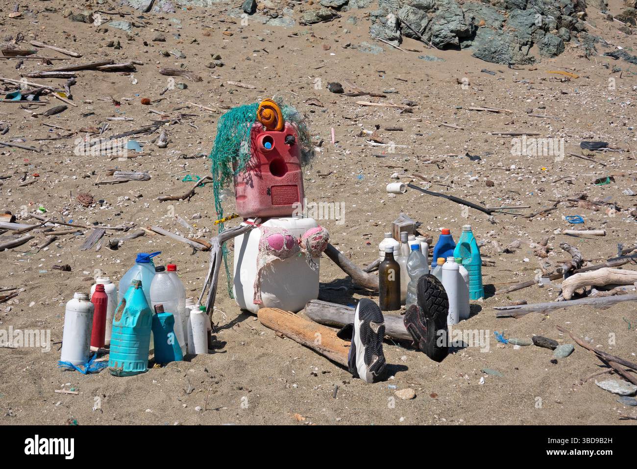Puppe am Strand, aus verschüttetem Abfall, tragisches Symbol der Umweltverschmutzung Stockfoto