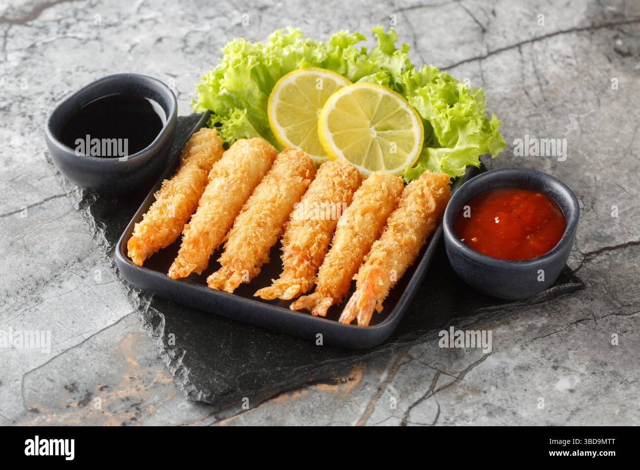 Tempura frittierte EBI-Garnelen mit gewürzten Saucen Nahaufnahme auf dem Teller auf dem Tisch. Horizontal Stockfoto