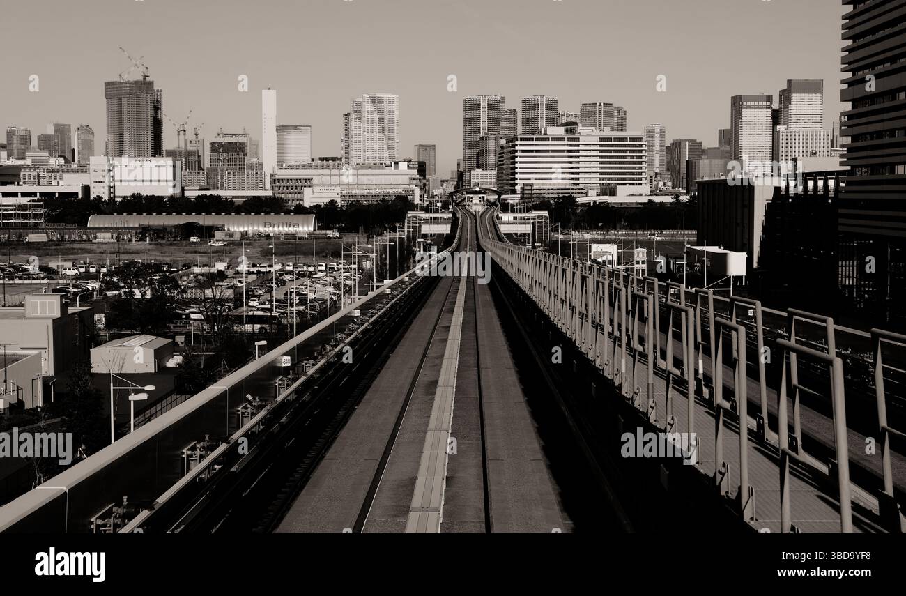 Monochromer Blick auf die Strecken der Yurikamome Line, der aus der Sicht des Fahrers in Tokios futuristische Skyline führt Stockfoto