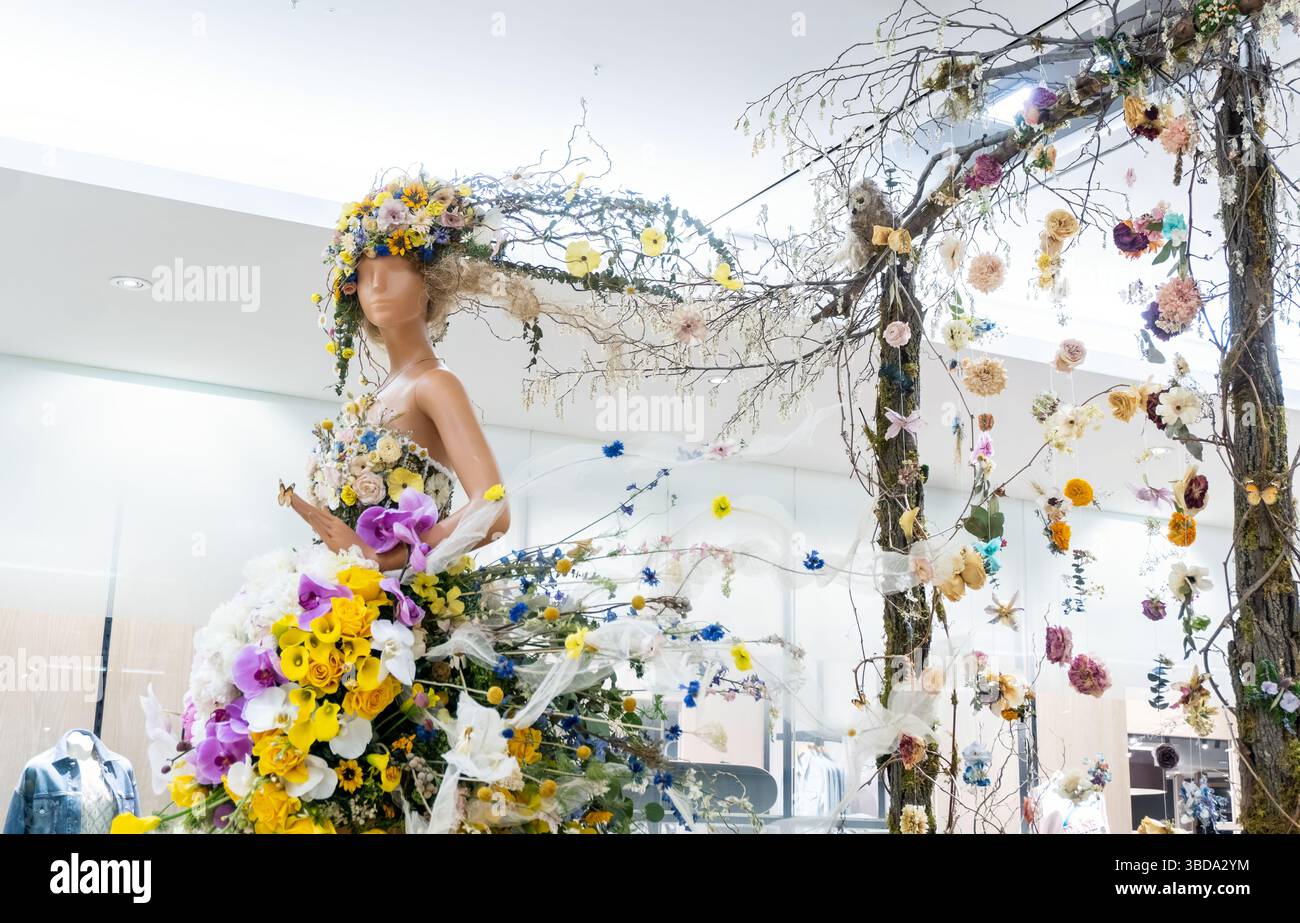 Braut-ähnliches Männchen mit Blumenkleid und Kopfkranz während des Fleurs de Villes Spring 2025 im Manulife Centre, Bloor-Yorkville, Toronto, Ontario, CAN Stockfoto