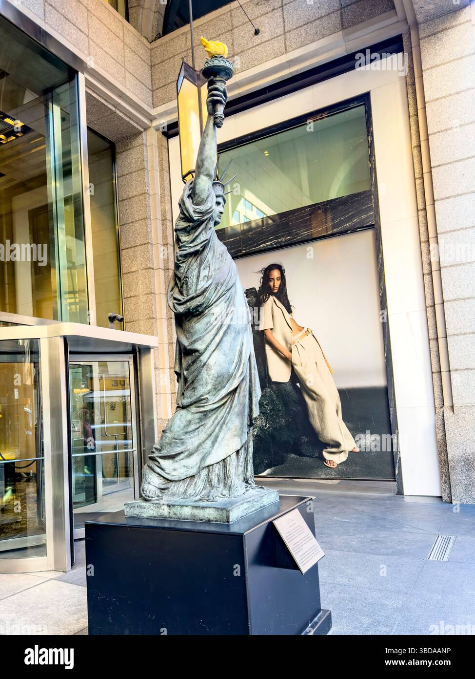 Die ursprüngliche Freiheitsstatue, Skulptur von Frédéric Auguste Bartholdi auf der East 61st und Werbespot mit einem modernen New York City, NY, USA - Smartphone-aufgenommenes Stockfoto
