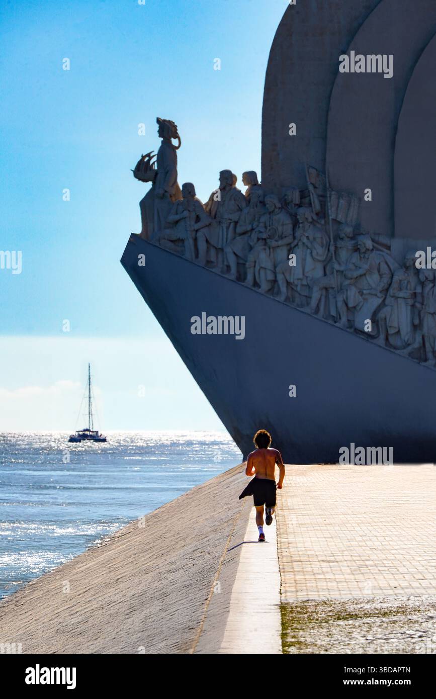 Ein gesunder junger Mann läuft entlang des Targus in Richtung des Denkmals der Entdeckungen in Lissabon, Portugal Stockfoto
