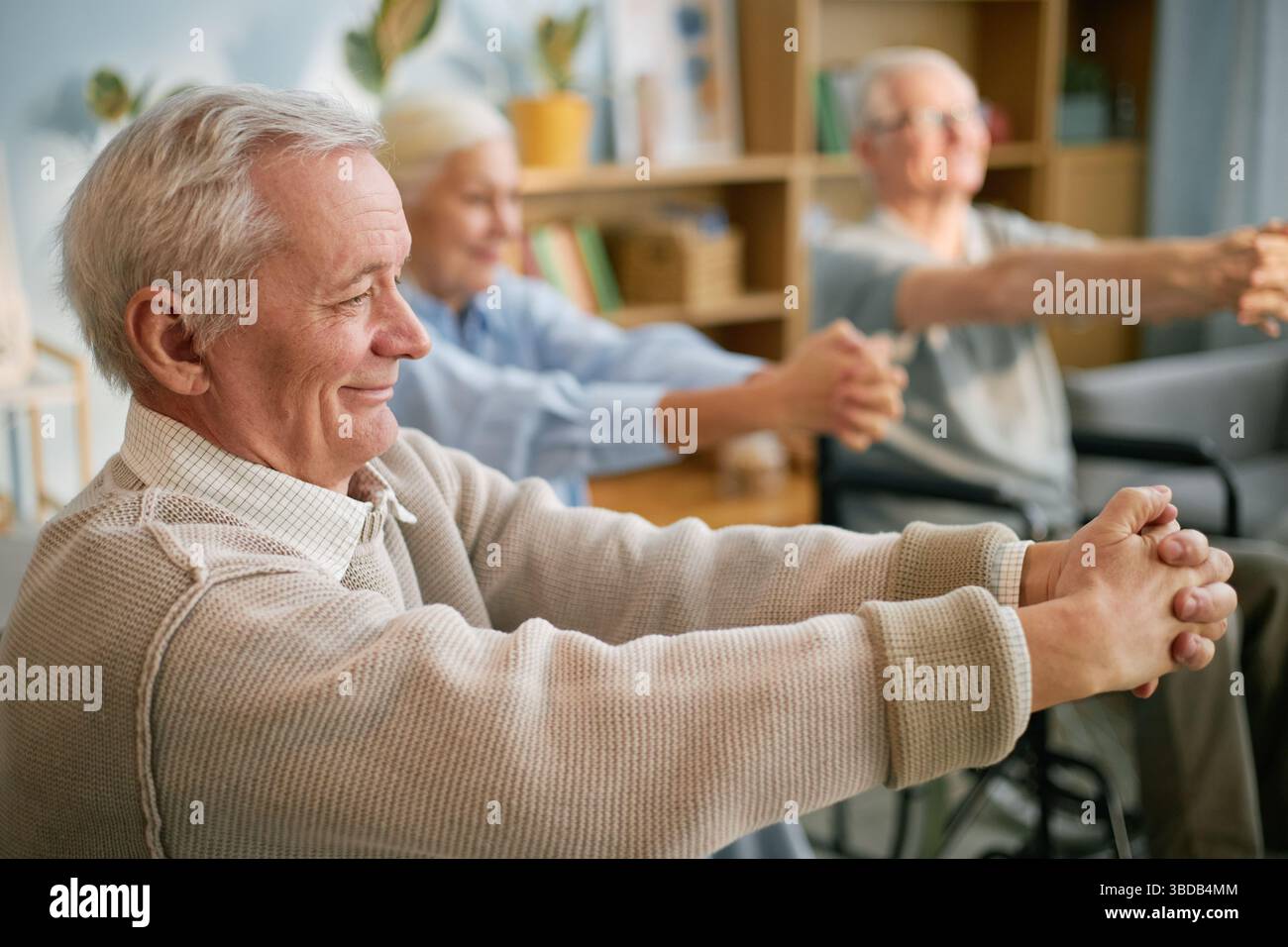 Senioren, die sich im Altersheim bewegen und Strecken Stockfoto