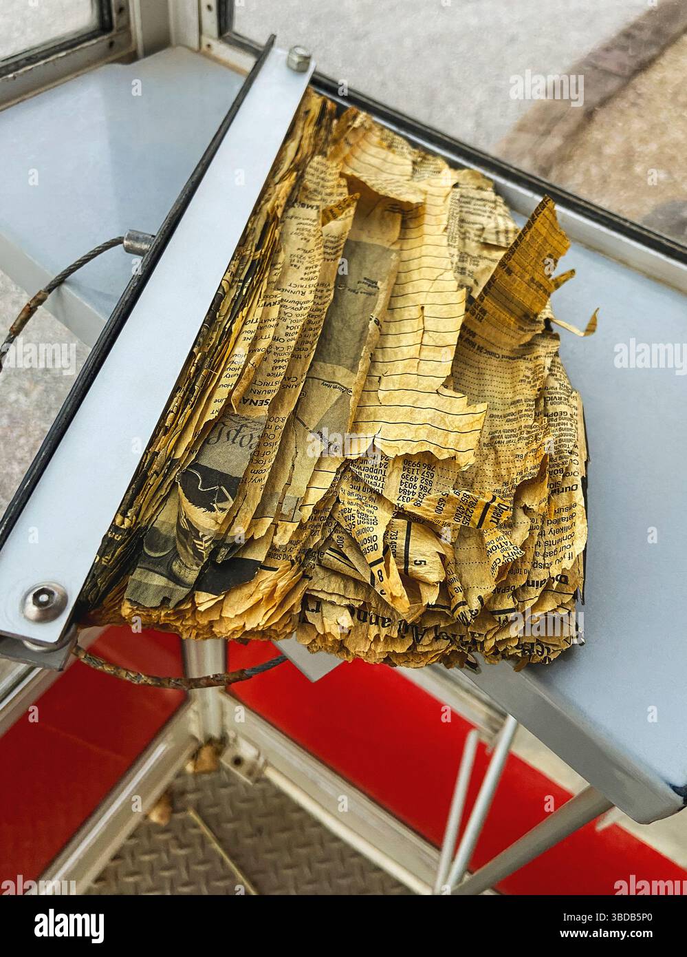 Zerrissenes und zerrissenes Telefonbuch in der alten Telefonzelle Stockfoto