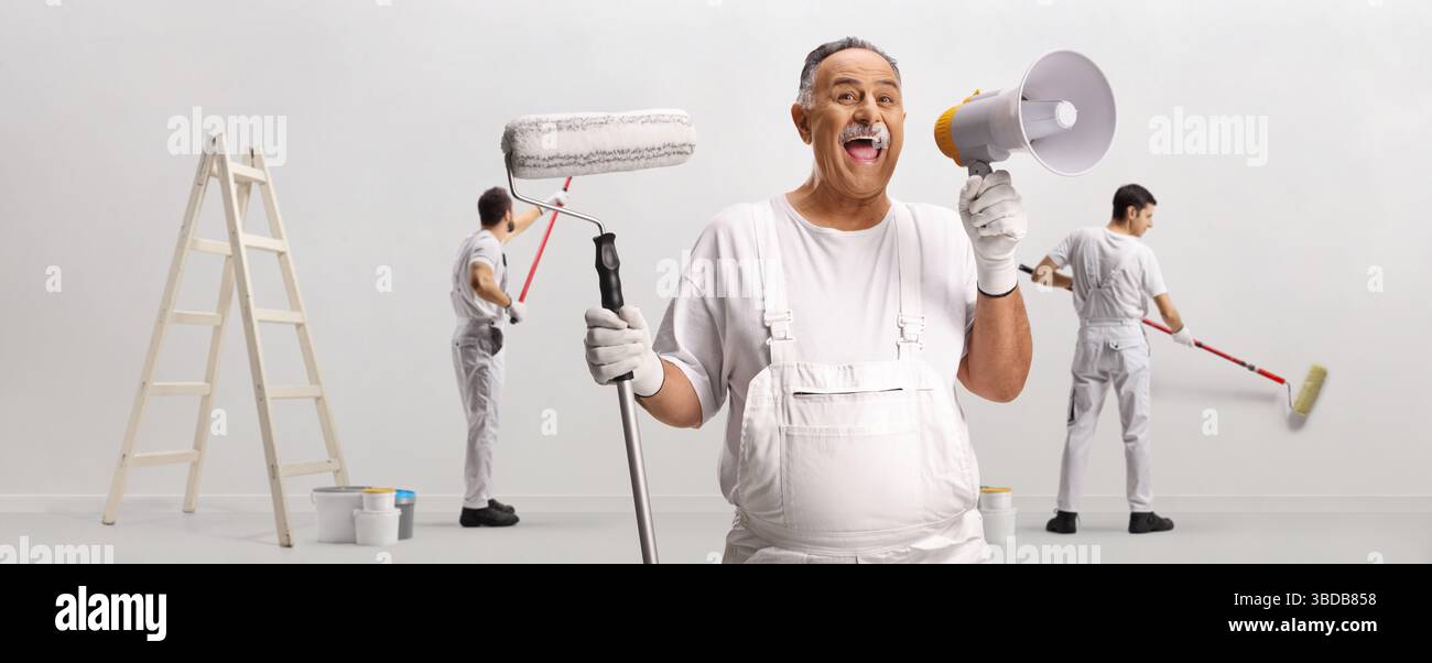 Maler, der eine Walze und ein Megaphon hält, und Arbeiter, die eine Wand auf weißem Hintergrund malen Stockfoto