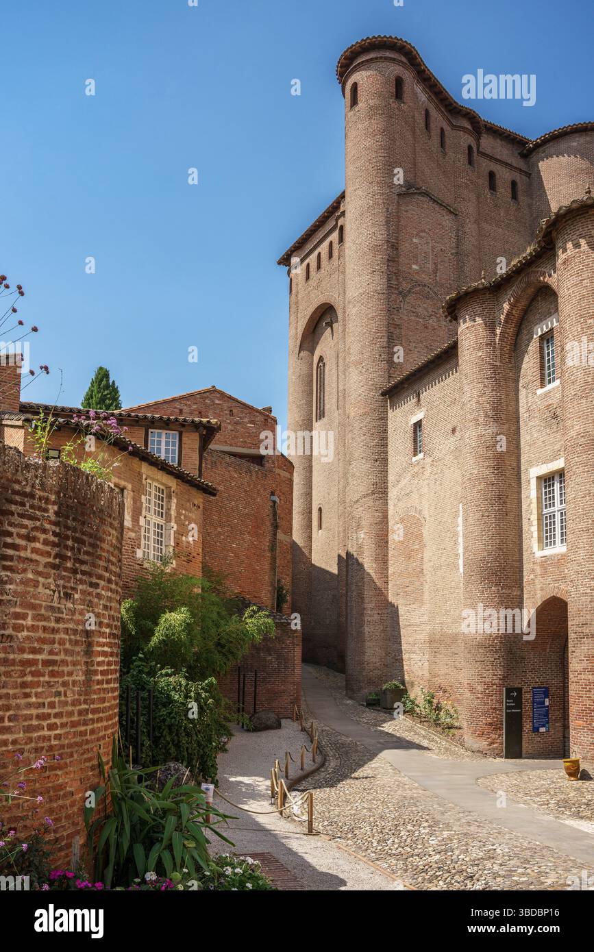 Der runde Turm des Berbie Palace erhebt sich über eine ruhige Backsteinstraße mit Grün in Albi Frankreich, Teil des UNESCO-Weltkulturerbes, befestigten Komplexes. Stockfoto