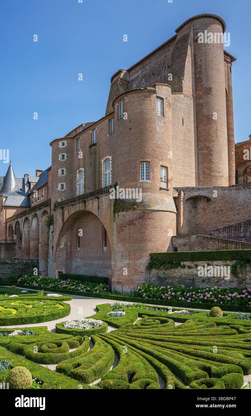 Geometrische Gartendesigns und Backsteinarchitektur umgeben den Berbie Palace in Albi, Frankreich, wo ein runder Turm über gepflegten Rasenflächen und kunstvoller Hecke steht Stockfoto