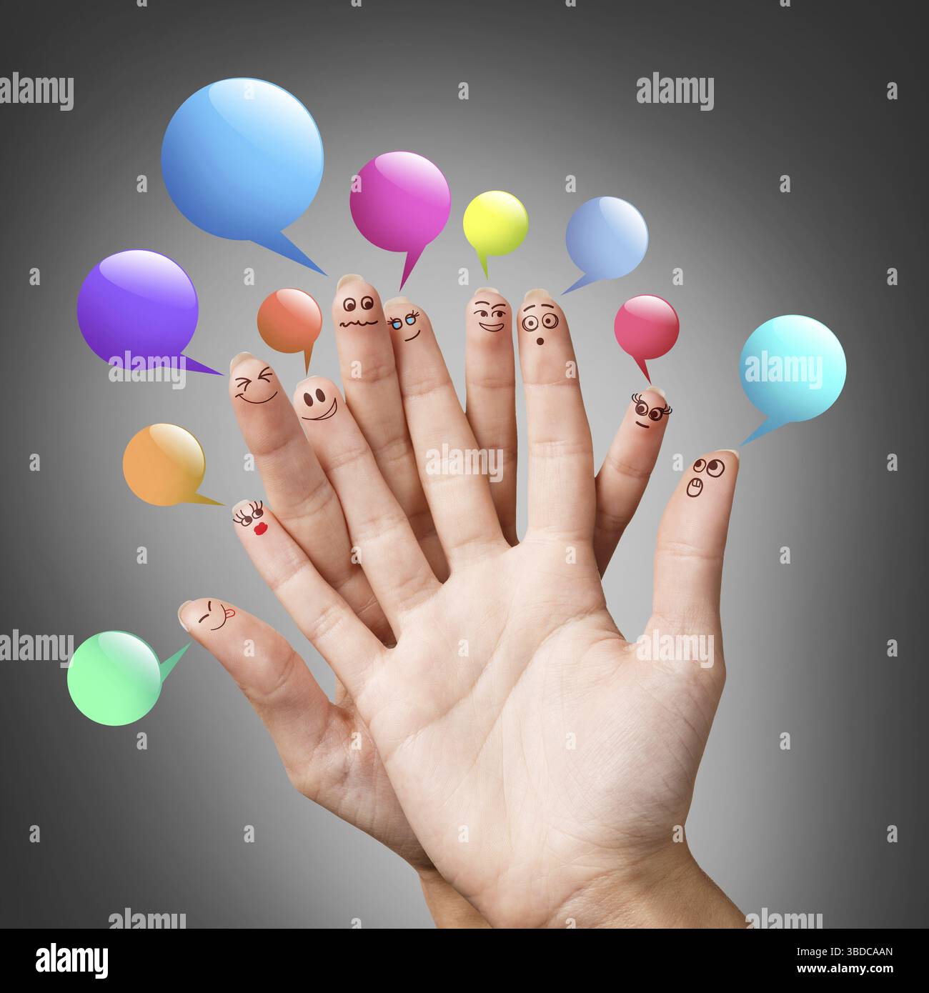Fröhliche Finger-Smileys mit bunten Sprechblasen auf grauem Hintergrund Stockfoto