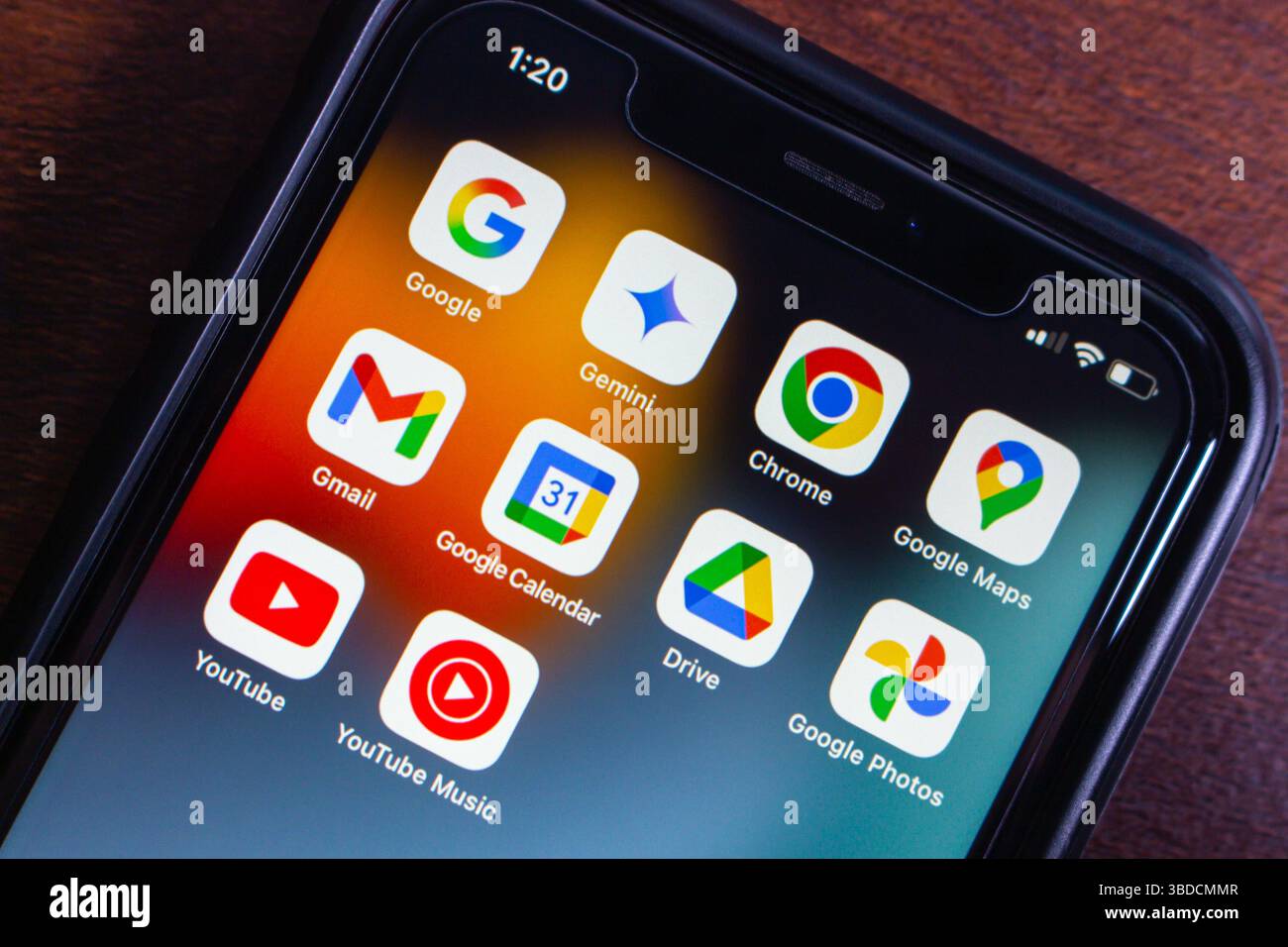 Angewinkelte Nahaufnahme eines Smartphones mit beliebten Google-Apps wie Gemini, Gmail, Chrome, Maps, Drive, und YouTube auf dem Startbildschirm. Stockfoto