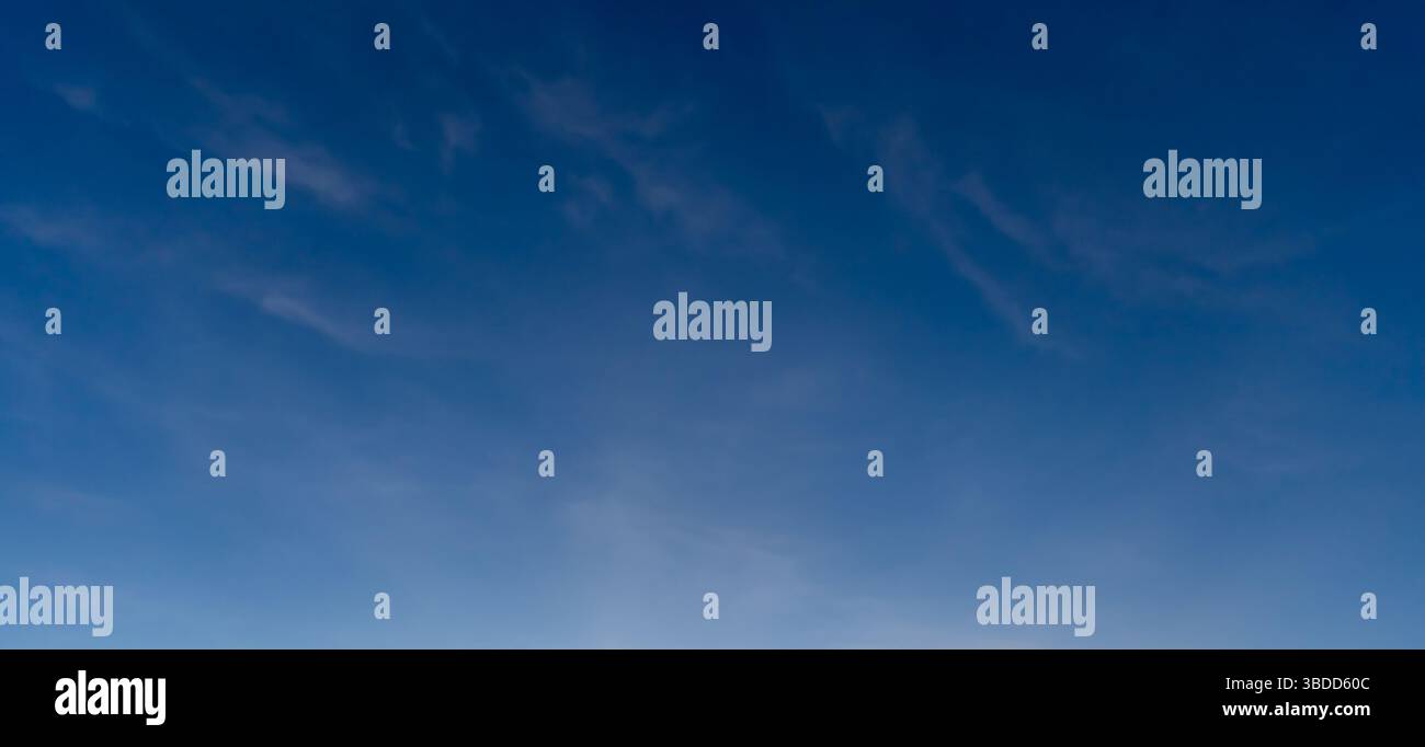 Niedriger Winkel und voller Rahmen des wunderschönen blauen Himmels mit seltsamer Form dünner weißer Wolken am Morgen oder Nachmittag an sonnigen Tagen Stockfoto