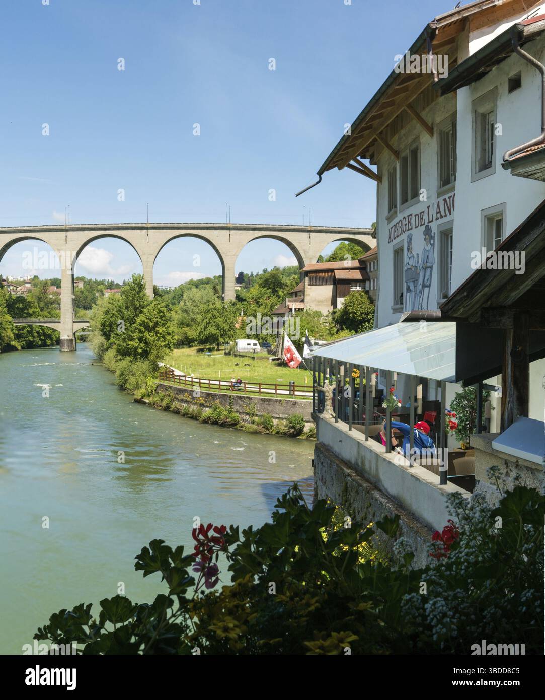 Schweiz - 30. Mai 2019: Restaurant an der Saane in Freiburg mit tollem Blick auf die moderne Poyabruecke Brige dahinter Stockfoto