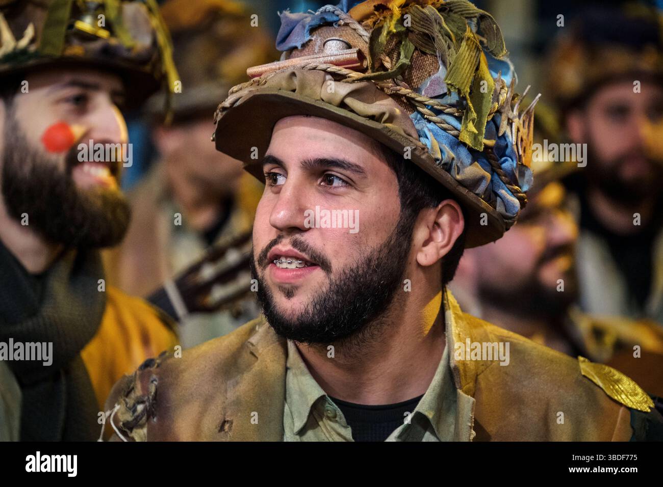 Auf diesem Bild sehen wir eine Gruppe von Männern, die wie Uniformen im Militärstil aussehen und mit Stoff- oder Papierelementen verziert sind, die ihnen einen verleihen Stockfoto Auf diesem Bild sehen wir eine Gruppe von Männern, die wie Uniformen im Militärstil aussehen und mit Stoff- oder Papierelementen verziert sind, die ihnen einen verleihen Stockfoto
