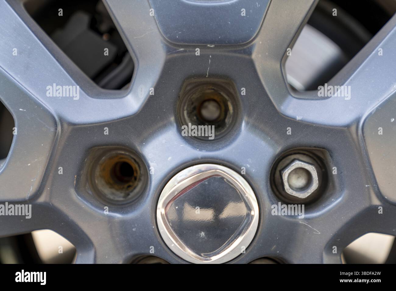 Nahaufnahme der Felge und des Rades eines Autos mit zwei gebrochenen Radmuttern Stockfoto