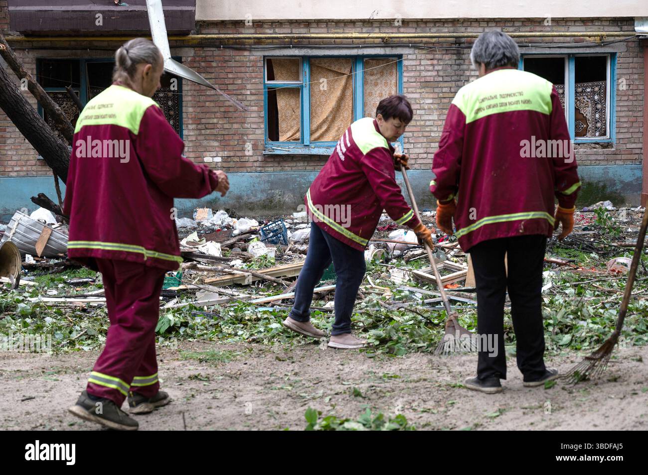 Kiew, Ukraine. Mai 2025. Versorgungsarbeiter entfernen die Trümmer außerhalb eines Wohnblocks im Bezirk Solomianskyi, der durch den russischen Raketen- und Drohnenangriff am 24. Mai 2025 in Kiew, Ukraine, beschädigt wurde. Kiew und sieben andere Regionen der Ukraine wurden von einem russischen Großangriff mit 250 Schlagdrohnen und 14 ballistischen Raketen angegriffen. (Foto: Danylo Antoniuk/Ukrinform) Credit: Ukrinform/Alamy Live News Stockfoto