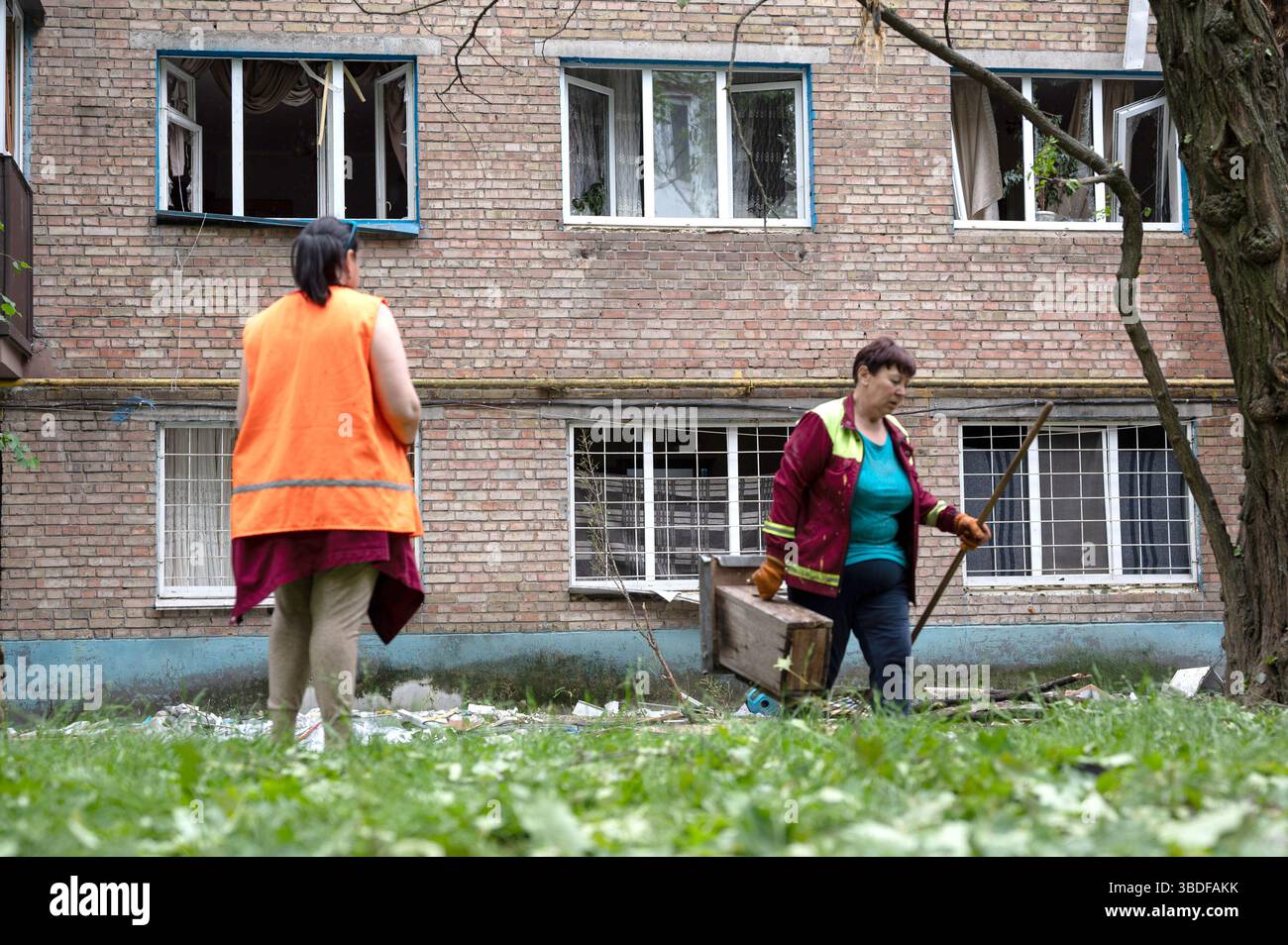 Kiew, Ukraine. Mai 2025. Versorgungsarbeiter entfernen die Trümmer außerhalb eines Wohnblocks im Bezirk Solomianskyi, der durch den russischen Raketen- und Drohnenangriff am 24. Mai 2025 in Kiew, Ukraine, beschädigt wurde. Kiew und sieben andere Regionen der Ukraine wurden von einem russischen Großangriff mit 250 Schlagdrohnen und 14 ballistischen Raketen angegriffen. (Foto: Danylo Antoniuk/Ukrinform) Credit: Ukrinform/Alamy Live News Stockfoto