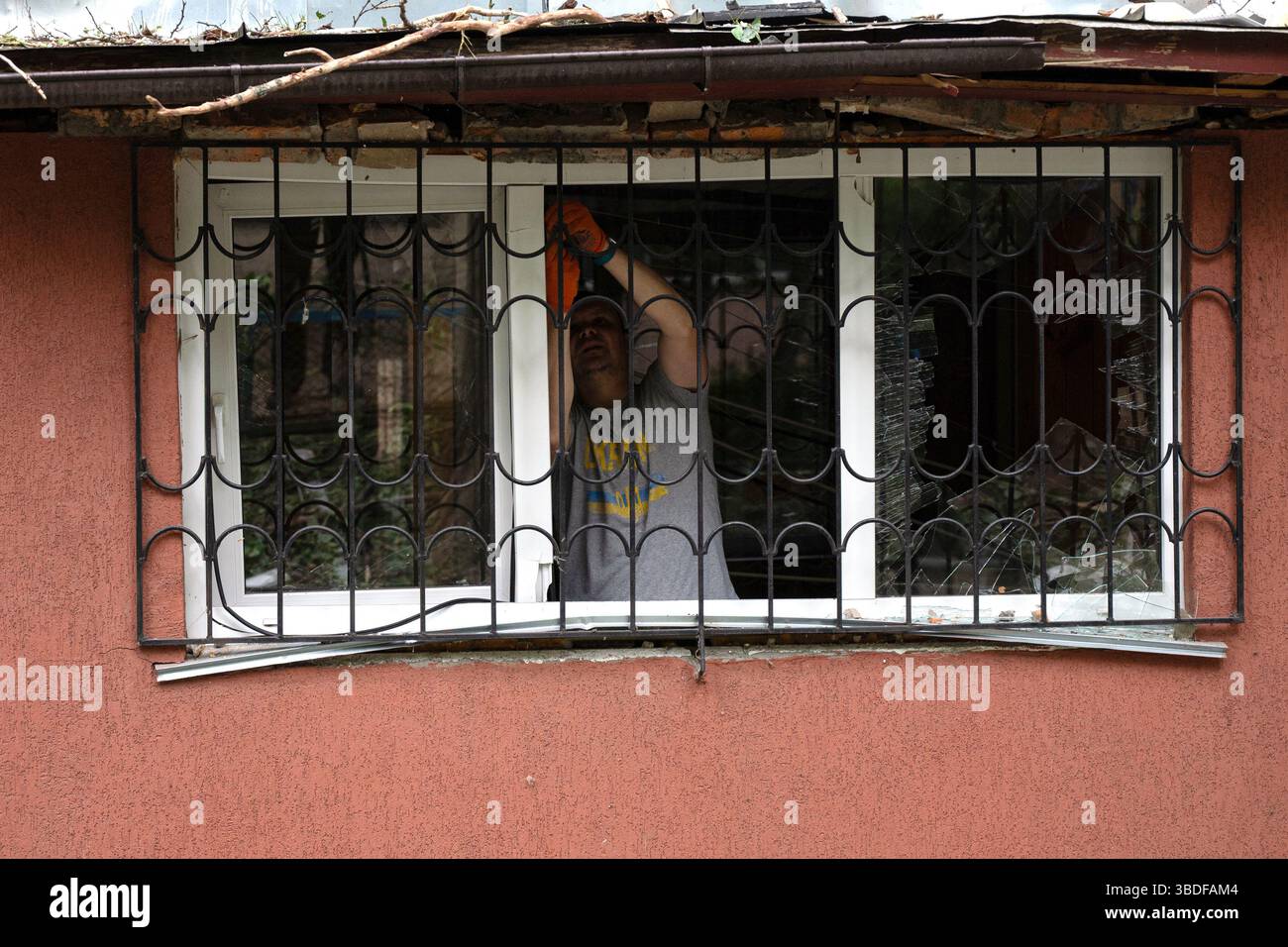 Kiew, Ukraine. Mai 2025. Ein Mann entfernt ein zertrümmertes Fenster in einem Wohnblock im Bezirk Solomianskyi, das durch den russischen Raketen- und Drohnenangriff am 24. Mai 2025 in Kiew, Ukraine, beschädigt wurde. Kiew und sieben andere Regionen der Ukraine wurden von einem russischen Großangriff mit 250 Schlagdrohnen und 14 ballistischen Raketen angegriffen. (Foto: Danylo Antoniuk/Ukrinform) Credit: Ukrinform/Alamy Live News Stockfoto