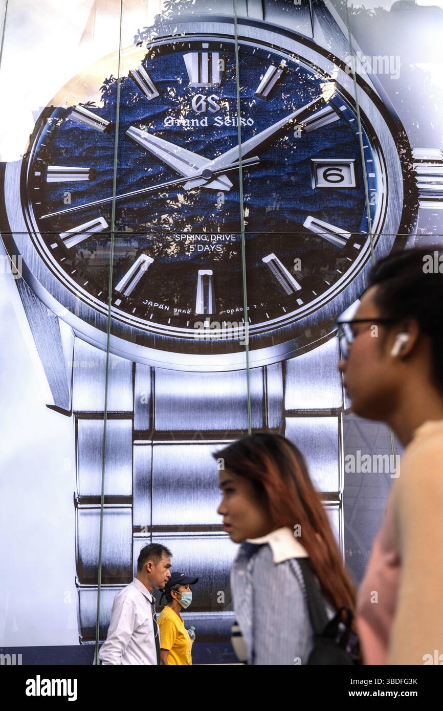 Bangkok, Thailand. März 2025. Eine geschäftige Einkaufsstraße mit Fußgängern, die an einer großen Werbung für die Luxusuhrmarke Grand Seiko in Siam S vorbeikommen Stockfoto